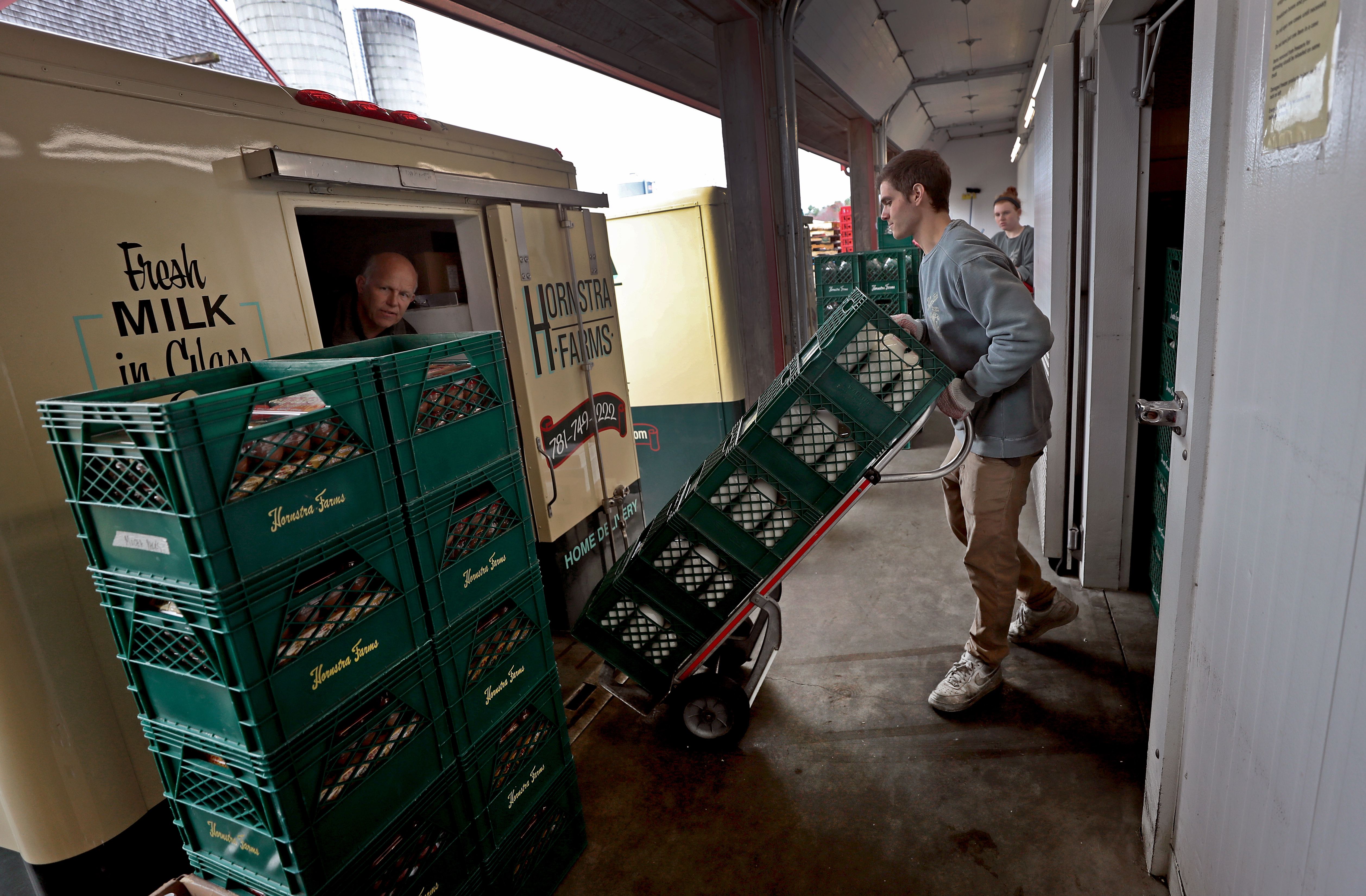 Jazper Petrelluzzi (right) loaded milk onto a truck while delivery driver Mike Onos checked on milk crates at Hornstra Farms.