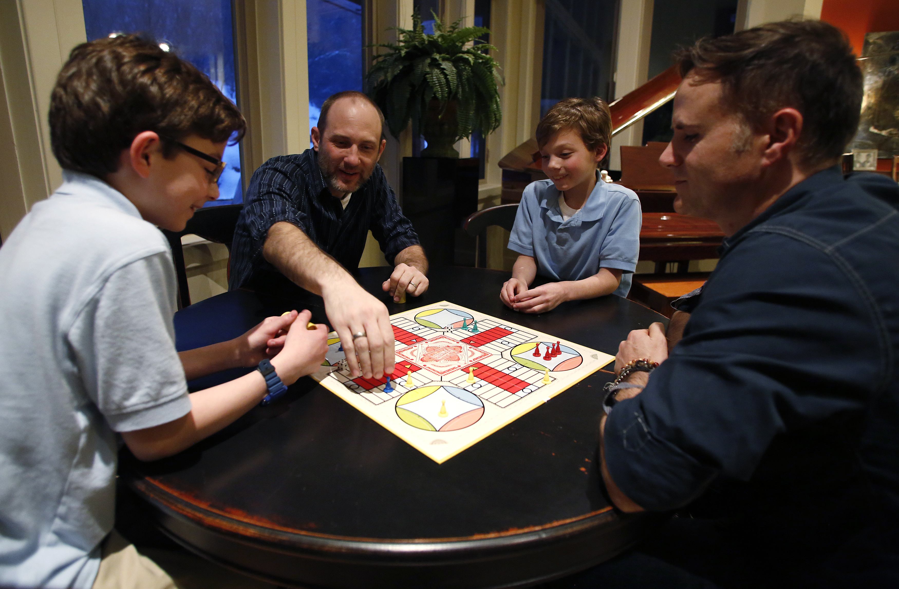 Tony Butterfield (2nd L) and his husband Paul Redd-Butterfield (R) play board games with their adopted 11 year-old twin sons Lucas (L) and Liam (2nd R) at their home in Sandy, Utah, January 8, 2014. Paul and Tony were legally married on December 23, 2013, but the Utah Governor's office has stated it will not recognize same-sex marriages pending a decision from the U.S. Supreme Court. REUTERS/Jim Urquhart (UNITED STATES - Tags: SOCIETY POLITICS)