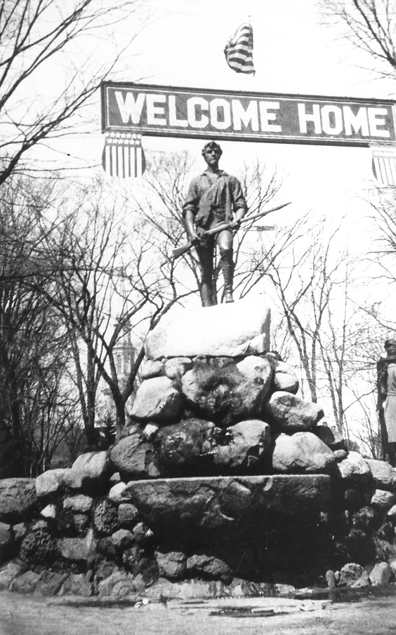 A welcome home sign for World War I soldiers hung over the Minute Man statue a century ago.