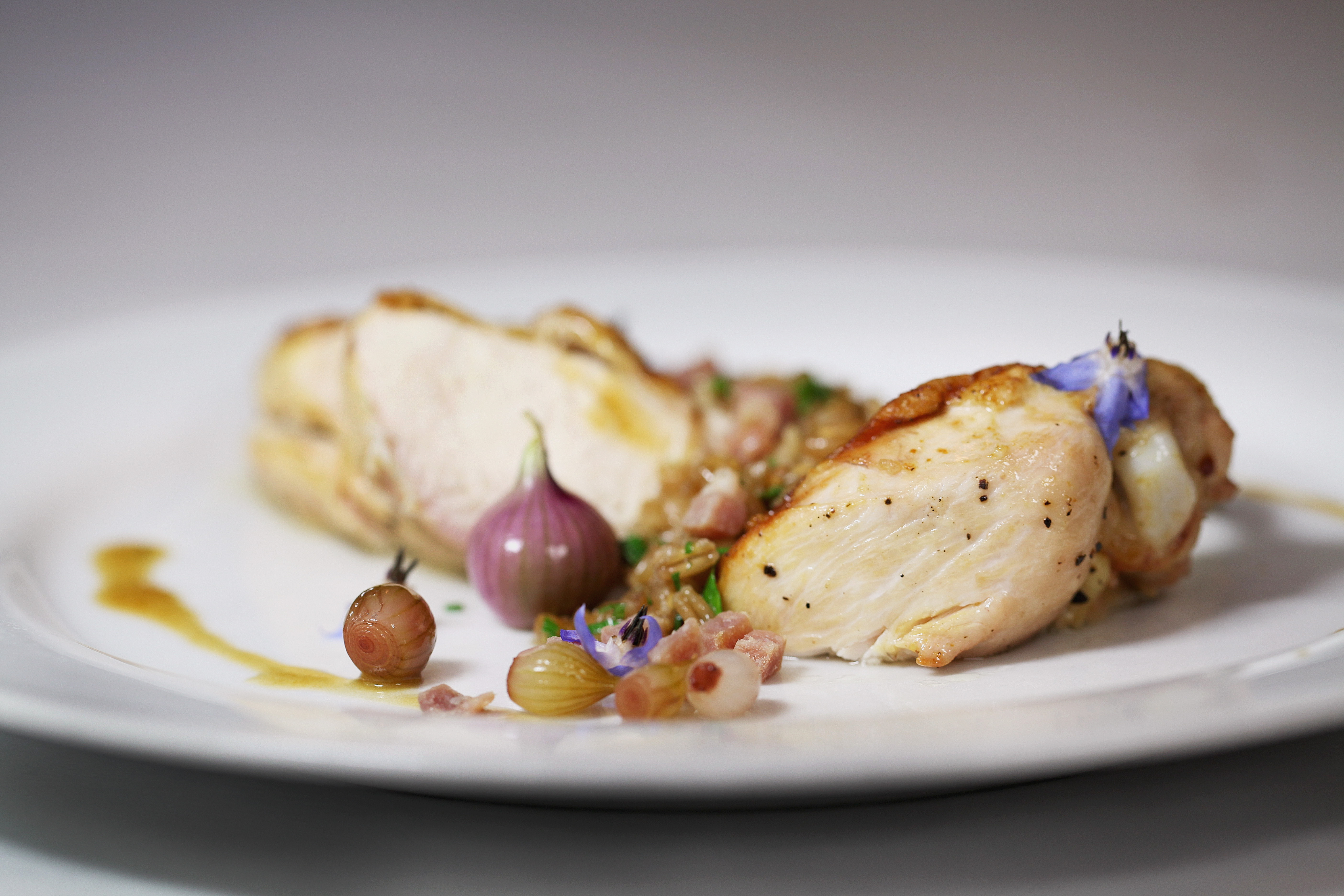 A dish of sweet-sour pickled onion — made with Egyptian walking onions — served with chicken breast.