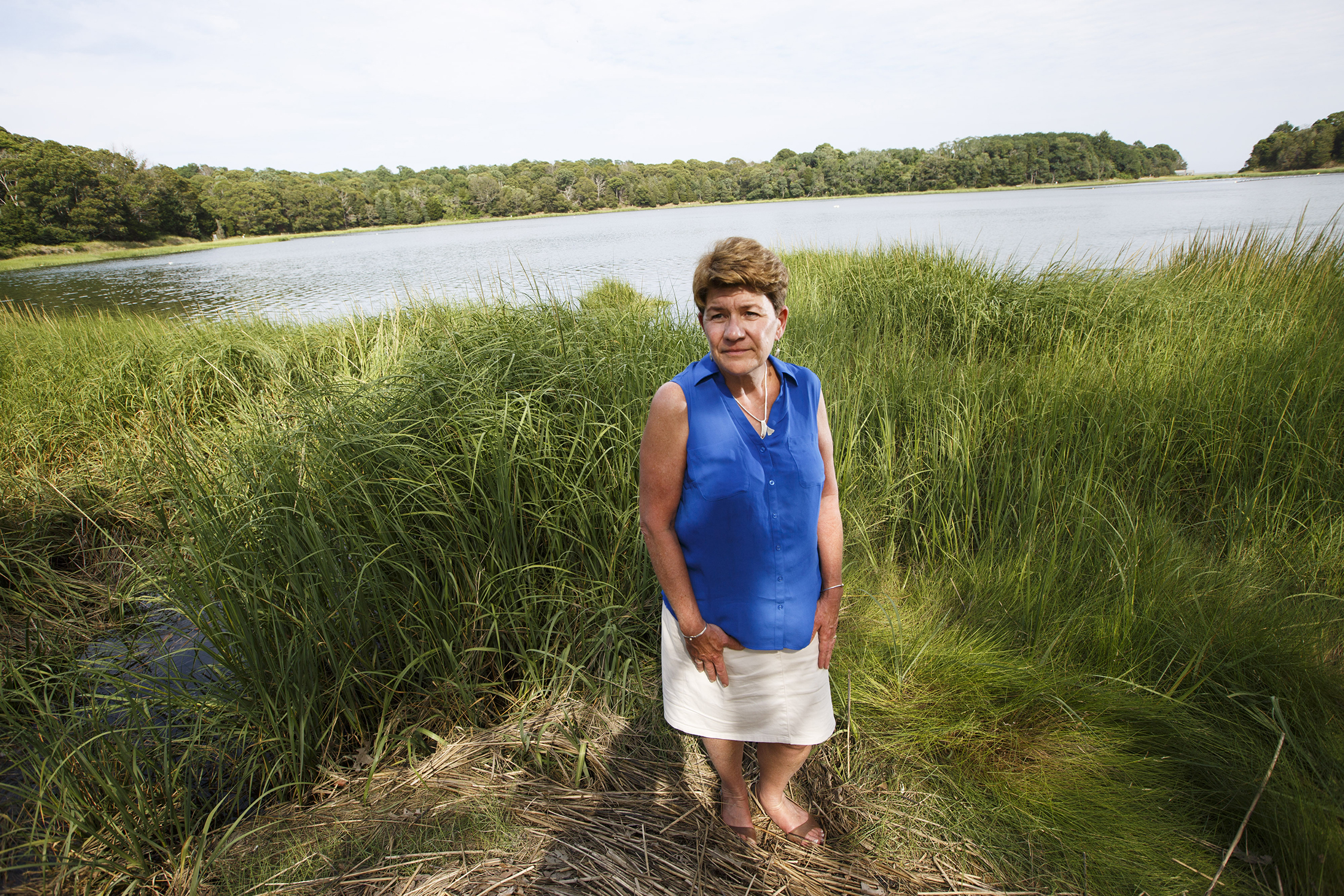 Eastham health agent Jane Crowley at the shore of the town’s Salt Pond, where storm runoff is spurring excessive algae growth.