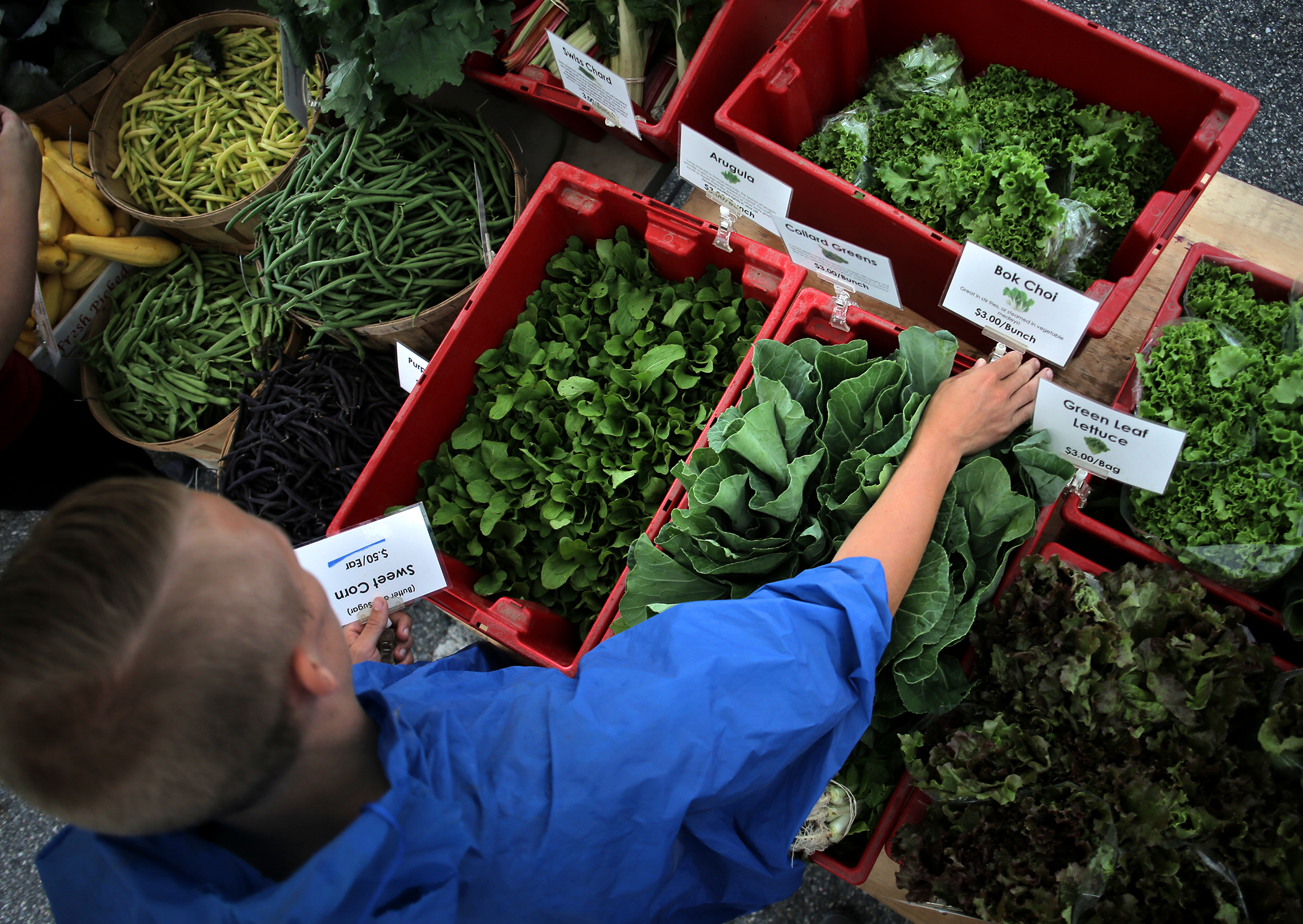 Kevin Bragg of Kimball Fruit Farm set up produce displays at the Brookline Farmers Market.