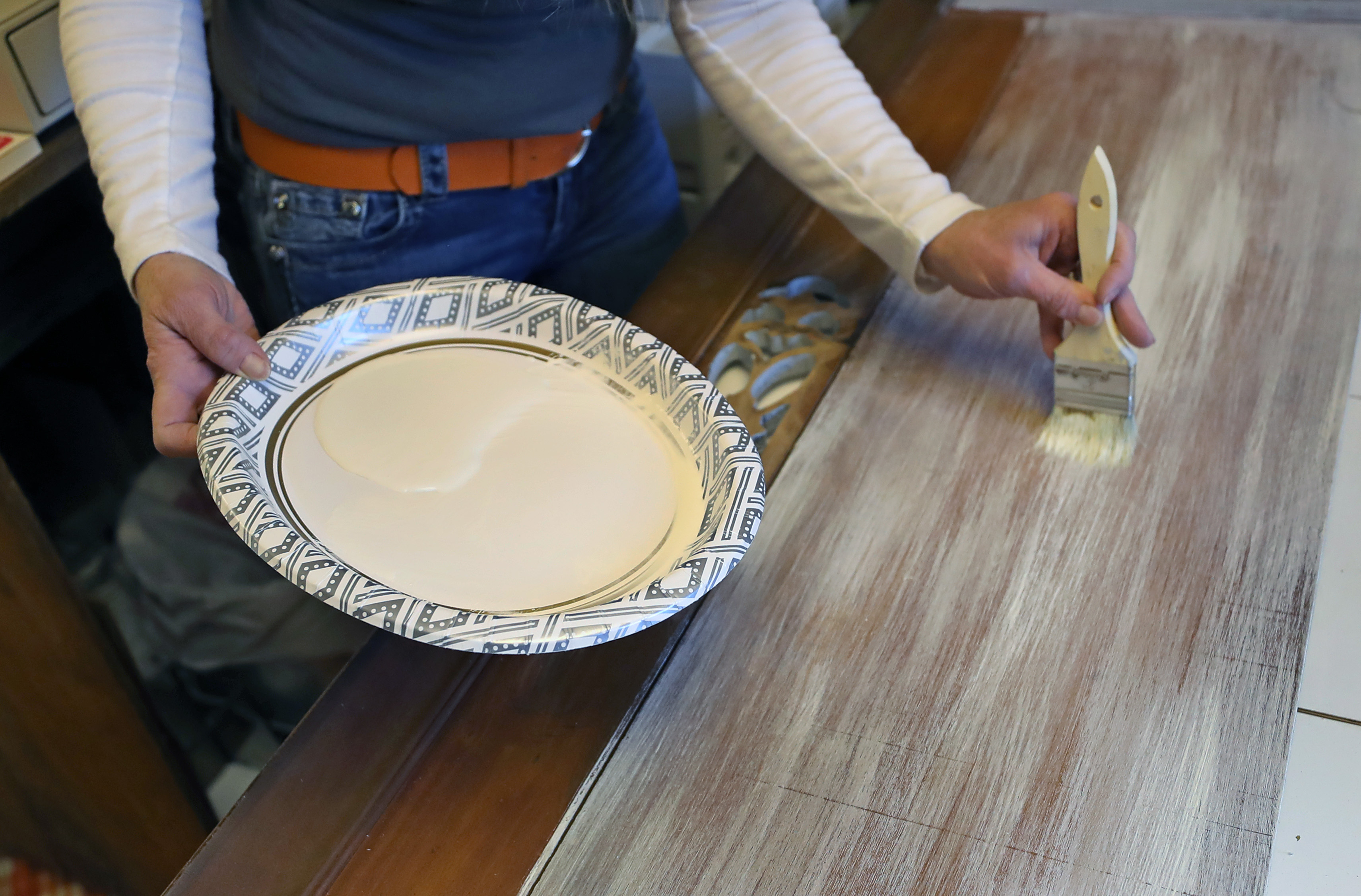 Pam Leonard shows how to brush paint on the bedboard.