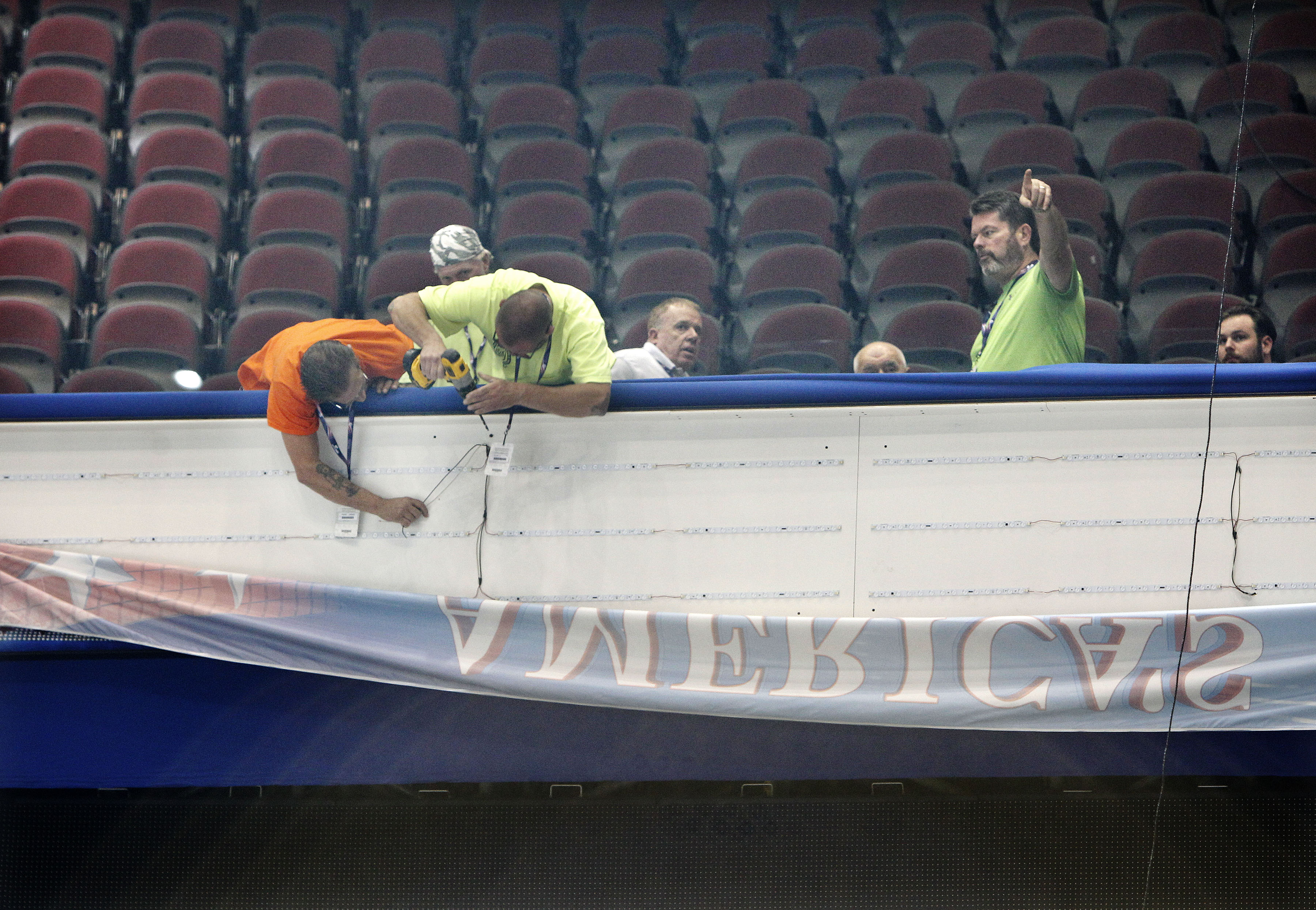 Workers hang a banner as preparations are underway for the Republican National Convention at Quicken Loans Arena in Cleveland.