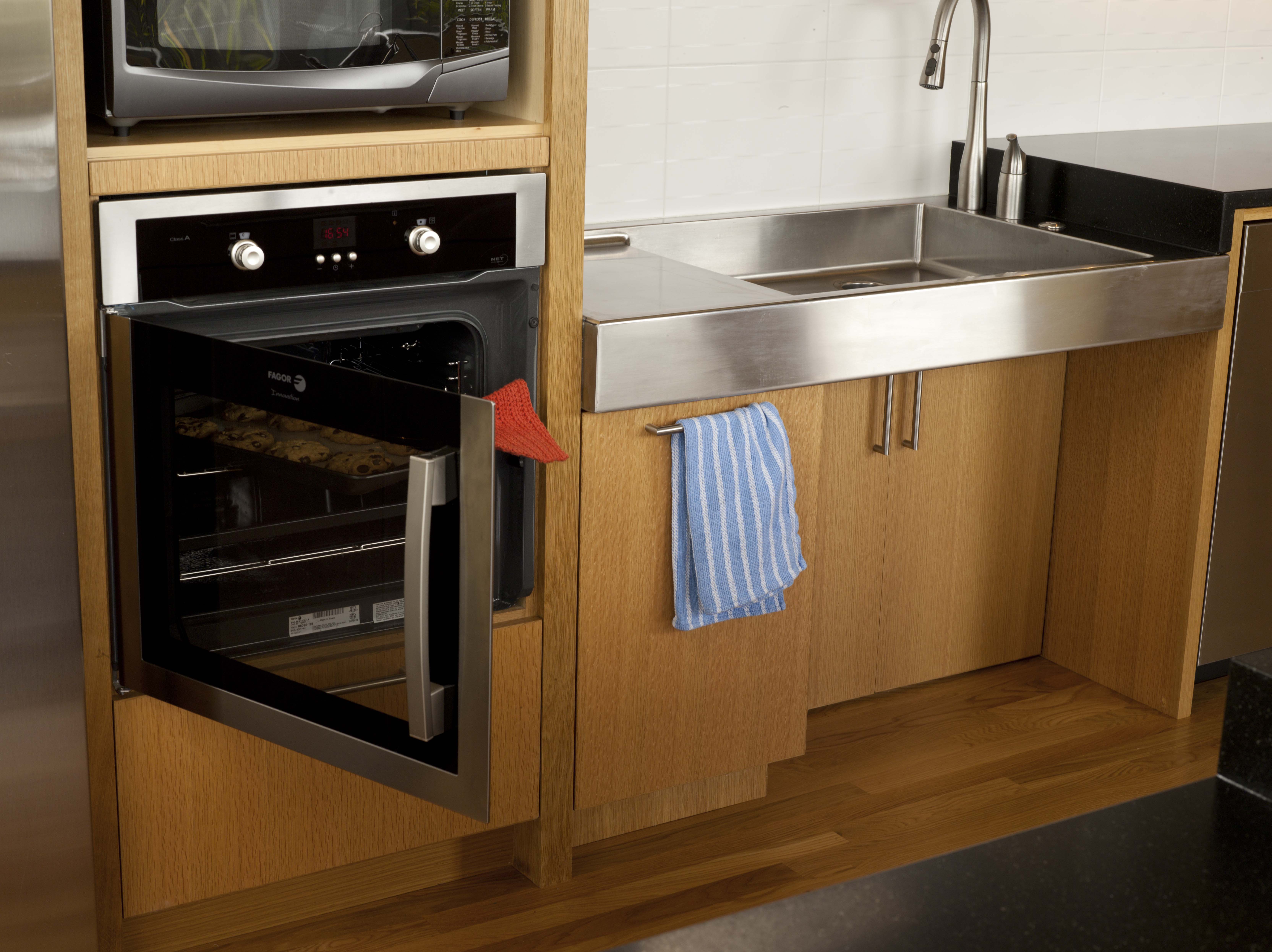 Recessing base cabinets allows a wheelchair user to reach the sink, and wall ovens put baking operations within comfortable range. “The Accessible Home” (The Taunton Press)