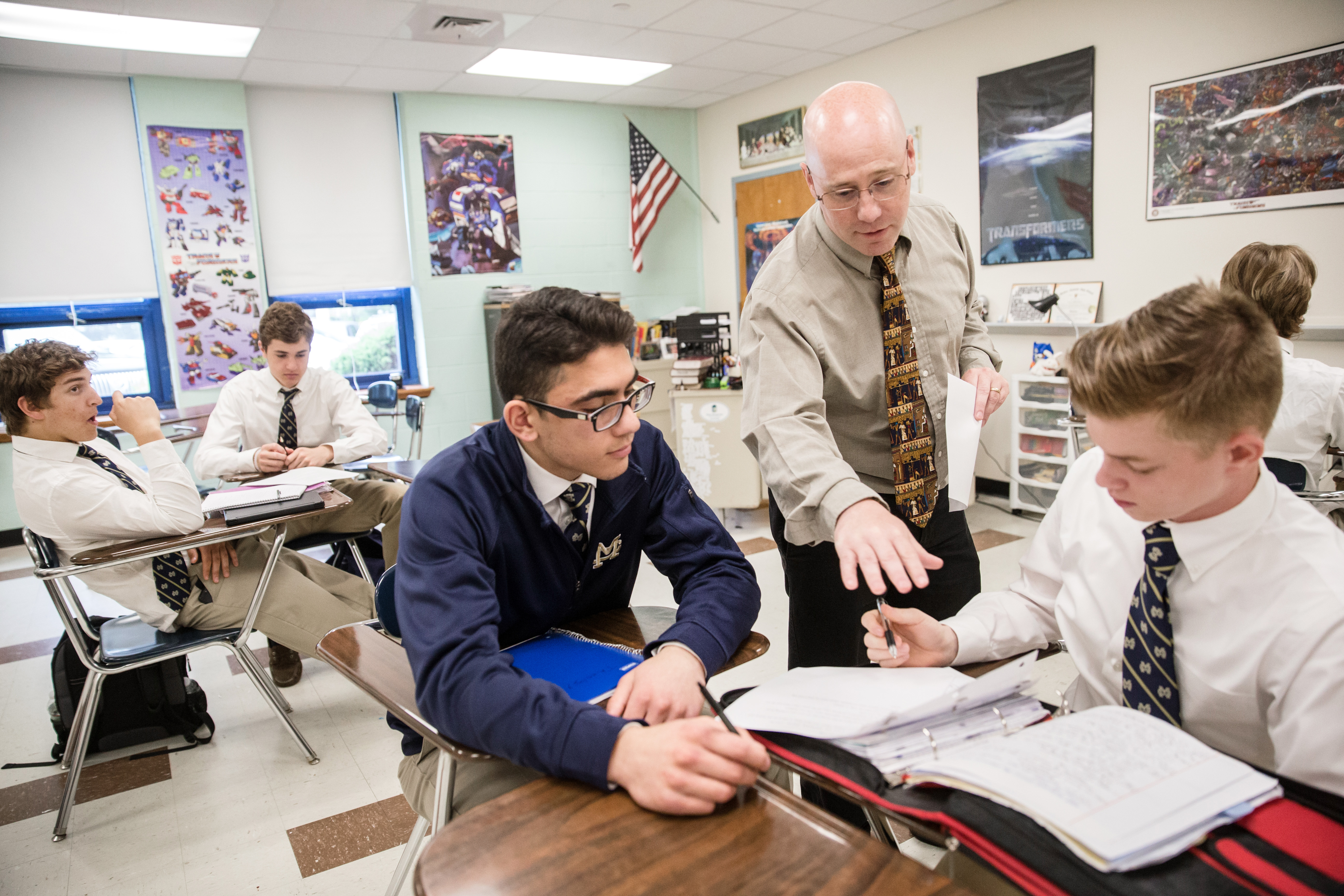 Eamonn Casey, center, helped students Dominic Odoguardi, left, and Kirill Mastracola, right, during a theology class at Malden Catholic High School.