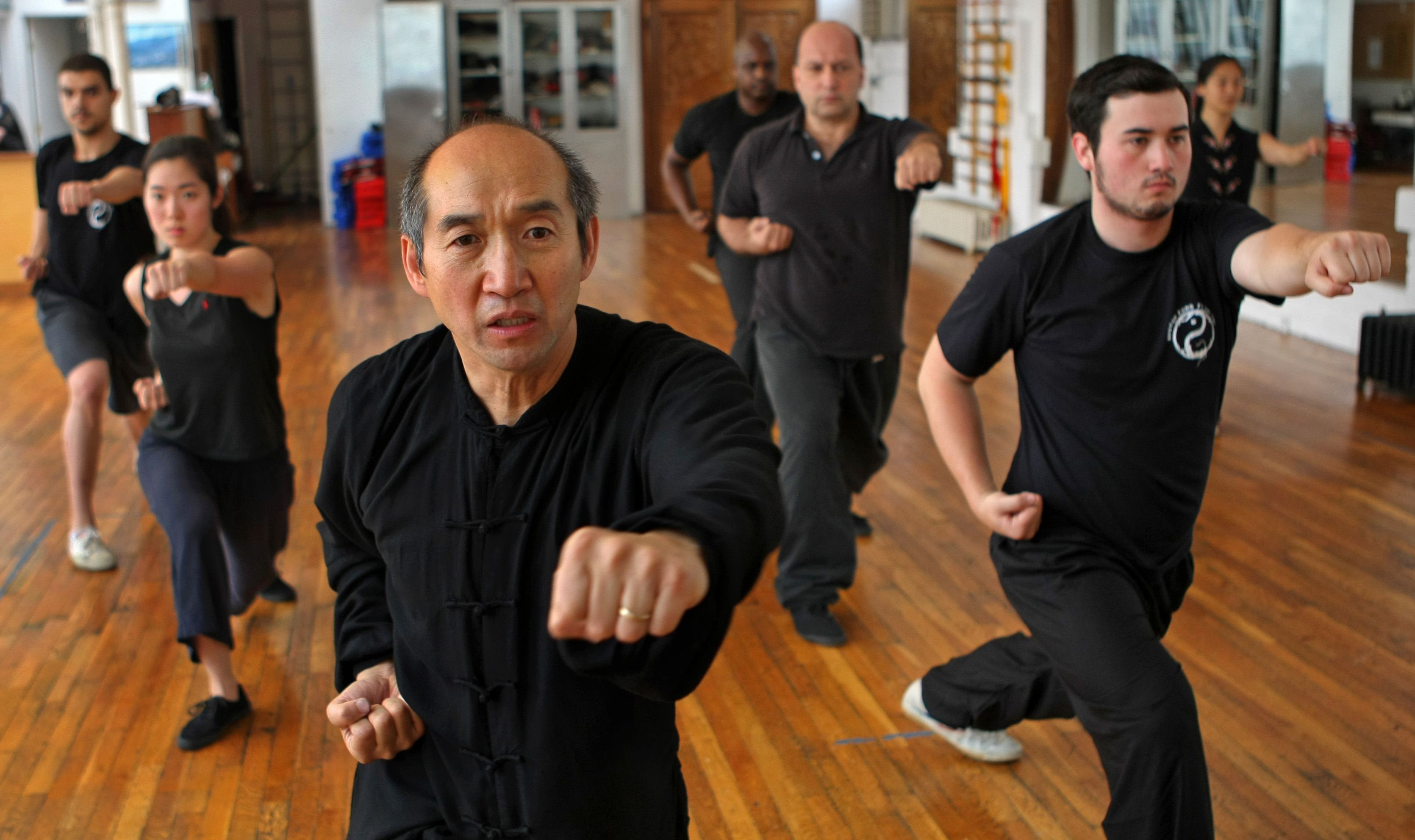 Boston, MA. 05/ 29 / 09: At Boston Kung Fu Tai Chi on Boylston St., kung fu and tai chi master Yao Li. (He is Giselle Bundchen's instructor, among other celebs -- The Sifu and the supermodel. His son Andy Li (cq) is on the right foreground attending his class. In the sunny fourth-floor dojo on Boylston Street, student and master move in unison. The student is Gisele Bundchen, who also happens to be the world's most highly-paid supermodel. Thousands of people know her name. The master is Yao Li. Not so many know his. At 52, Yao Li's students have included Celtics legend Robert Parrish, Aerosmith singer Steve Tyler, and playwright David Mamet, among other luminaries. But until Bundchen mentioned him in an interview last month, Li wasn't well known, even in Boston. "He could support himself with five really well-known students," said longtime friend Bruce Sandford, 58, of Westford. "But I don't think that would satisfy him." ( David L Ryan / Globe Staff ) section: g slug: 04sifu reporter Rosenbaum 11sifu Library Tag 06112009 G (Style/Arts/Things To Do)