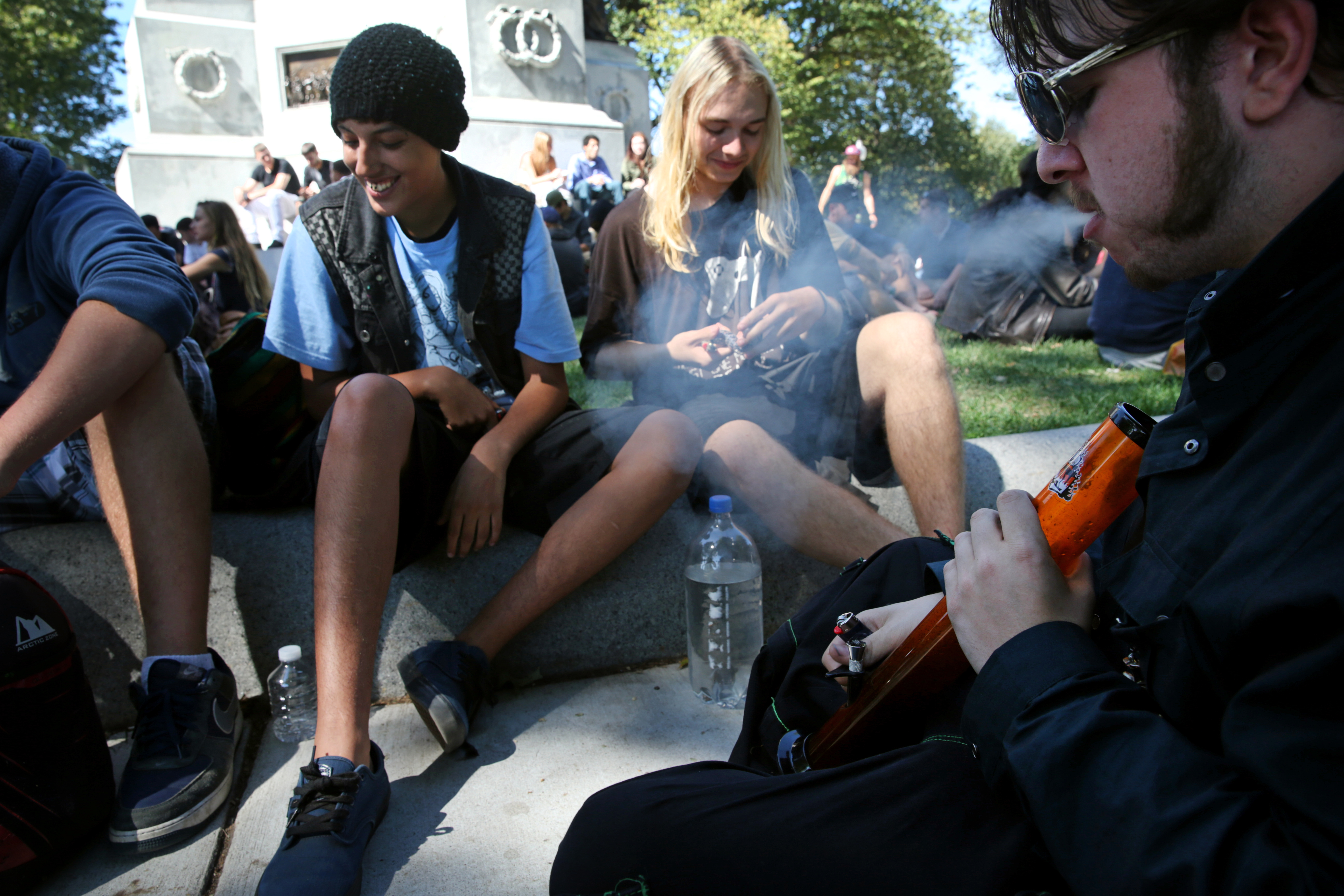 Eddie Curley , right, used a water pipe while smoking with friends during the Boston Freedom Rally on Sept. 17.
