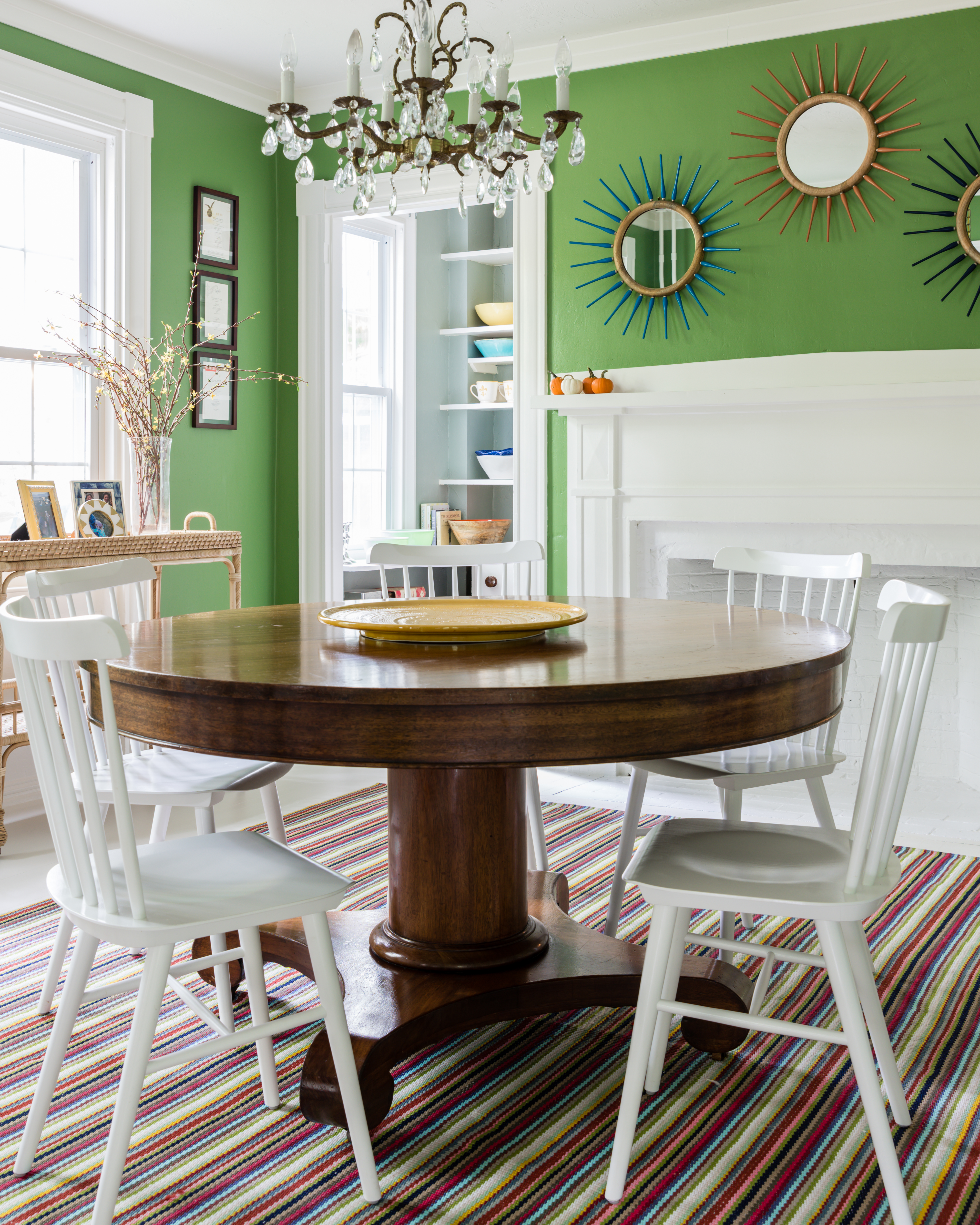 The dining room table, paired with Serena & Lily chairs, was a flea-market find that Bourque had refinished. The indoor/outdoor rug is by Dash & Albert, the mirrors are from Pottery Barn, and the chandelier is vintage.