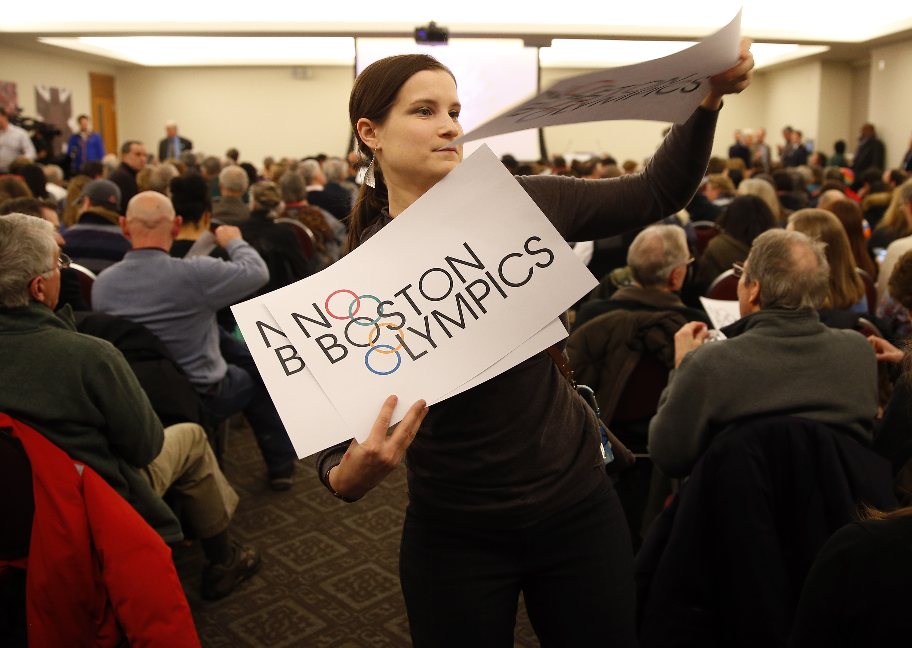 Somerville resident Claire Blechman handed out signs before the start of the community meeting.