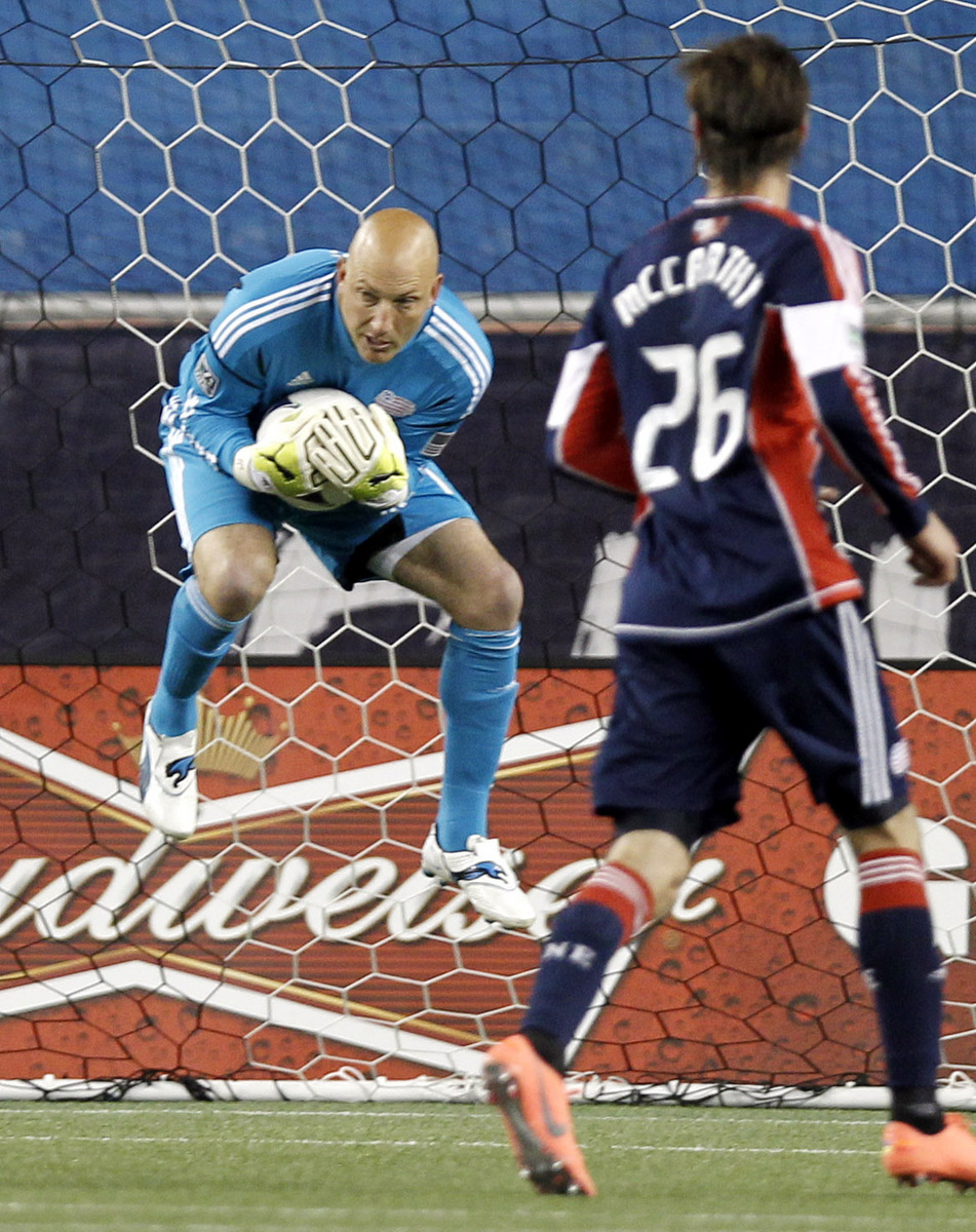 Matt Reis snags a shot with teammate Stephen McCarthy at the ready as the Revolution snapped a three-game losing skid.