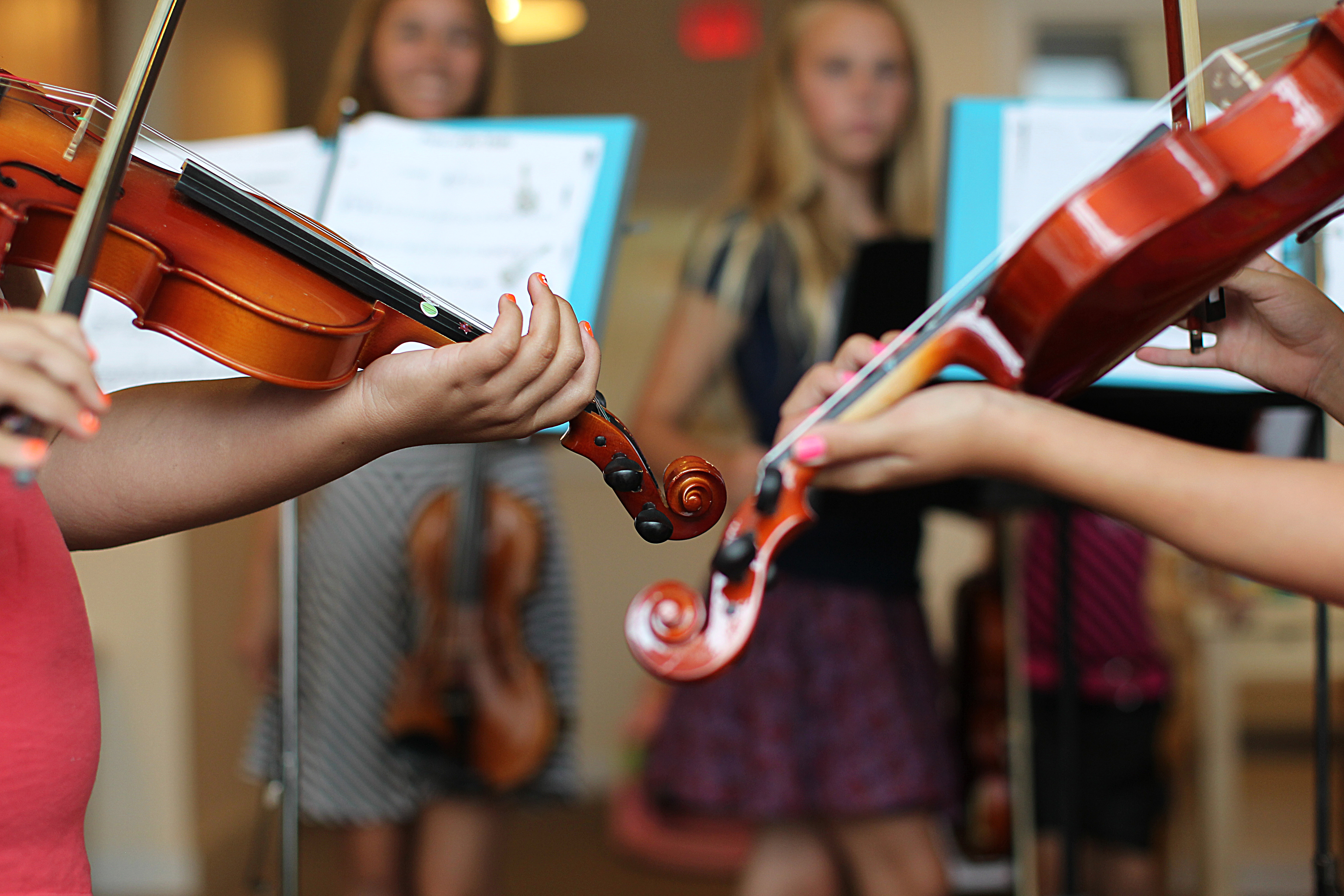 Sophia Spungin (background left) and Emily Swearingen, 13, supervised violin lessons for Vanessa and Angelina. Students’ families say music allows them to escape the reality of being homeless.