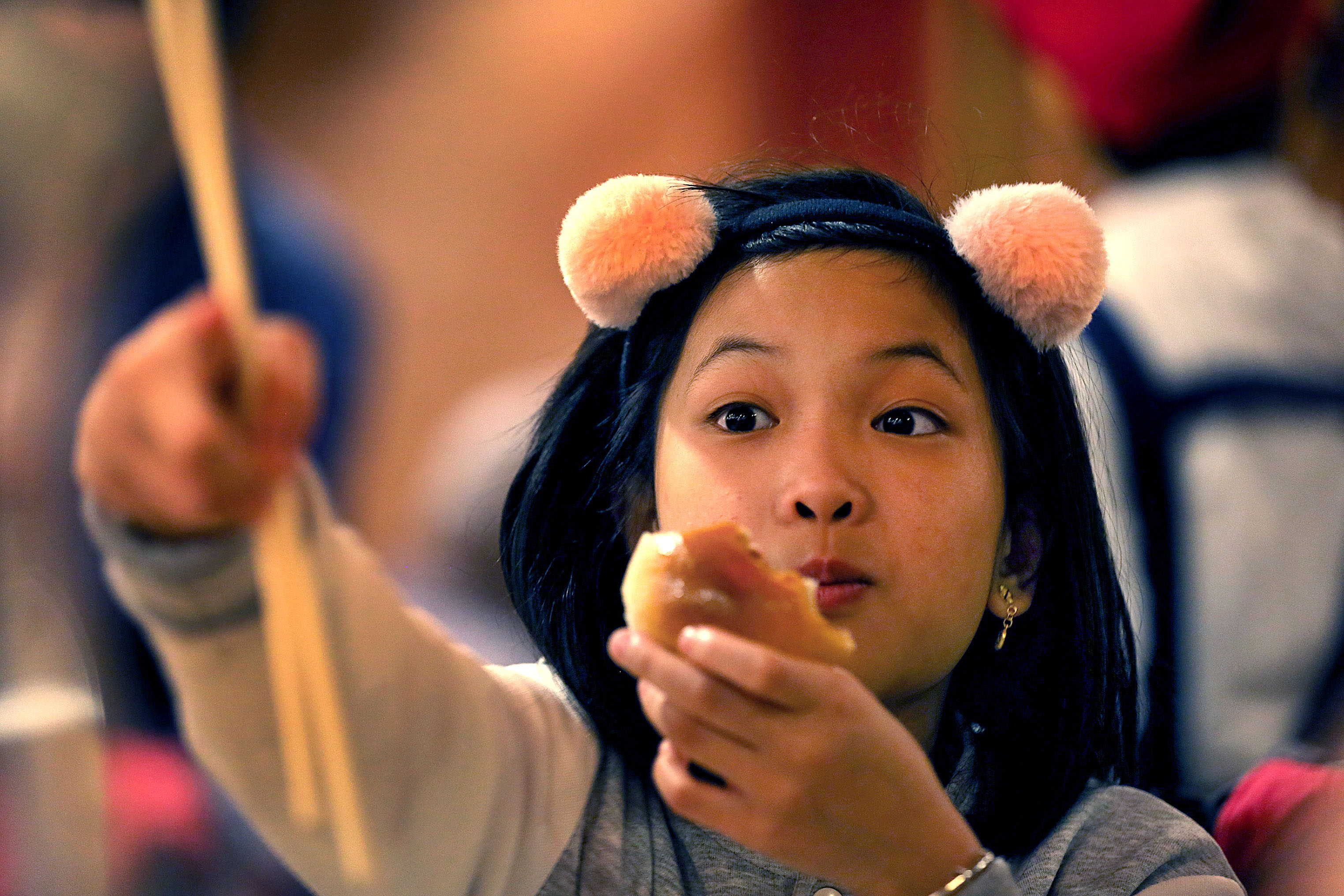 Mika Liu, 9, enjoys a roll as she holds her chopsticks.