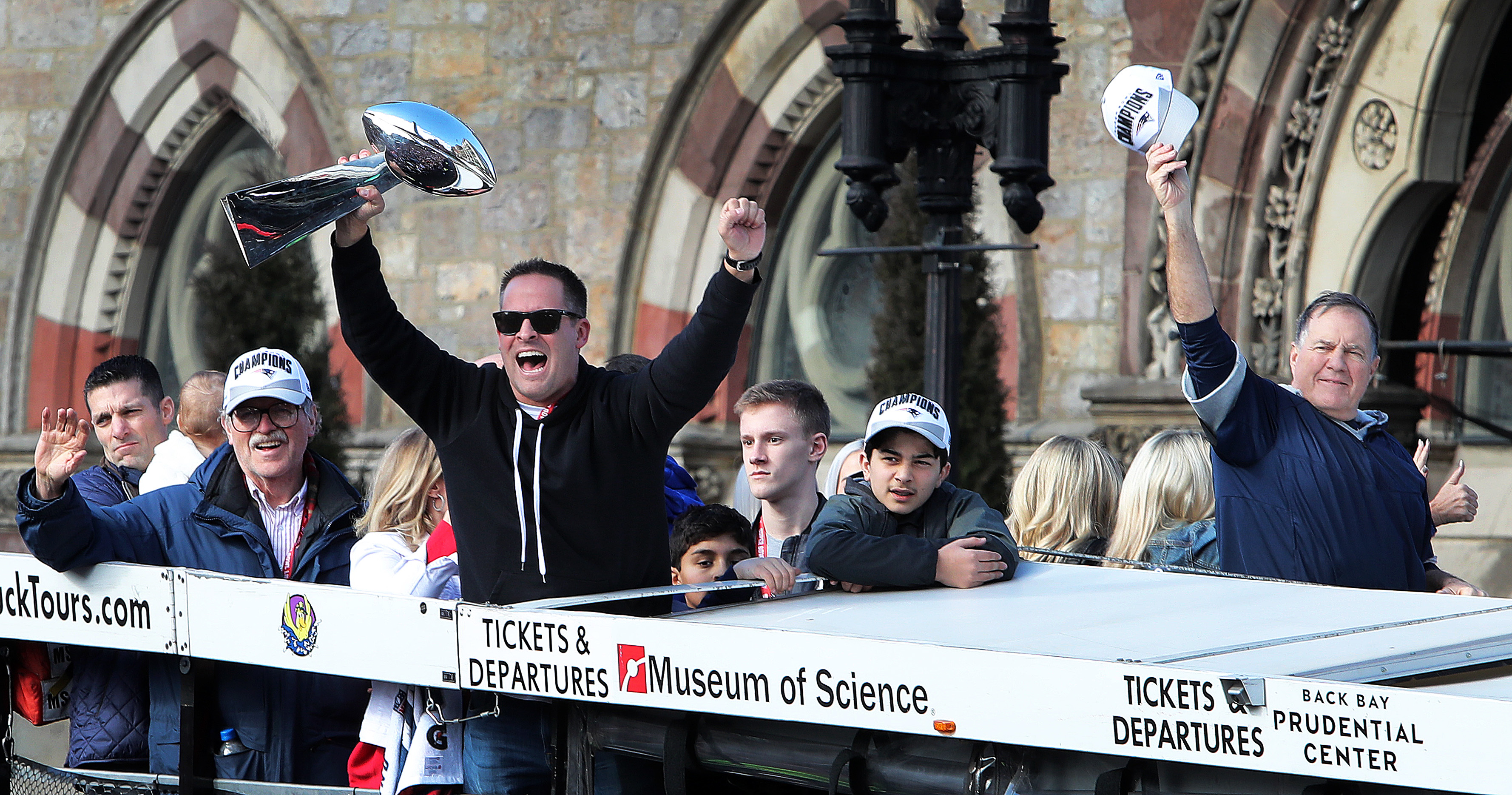 Josh McDaniels (center) hoists the Lombardi Trophy at the Patriots’ Super Bowl LIII victory parade in February. His college teammate and Patriots colleague Nick Caserio is at lower left.