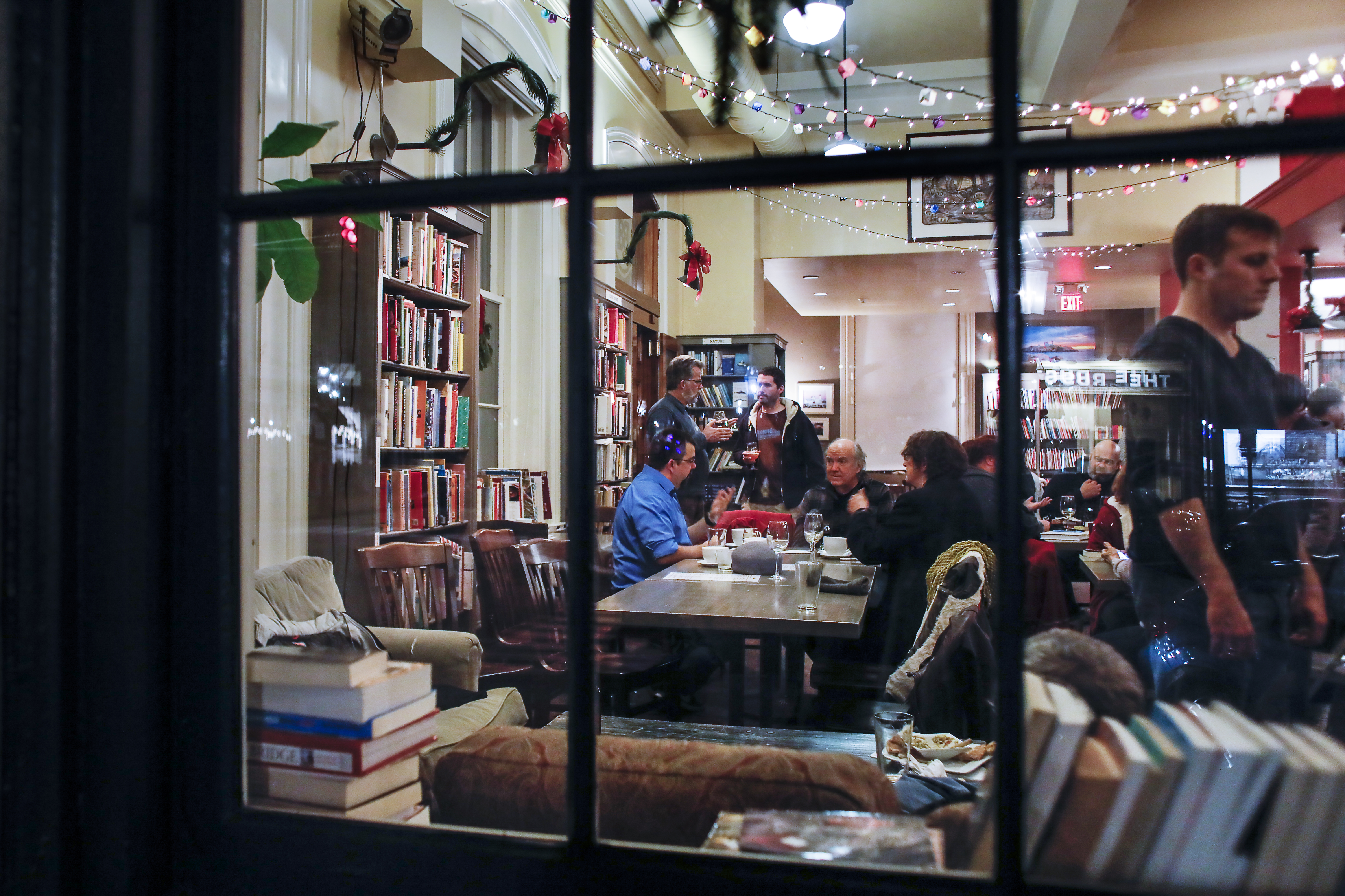 Viewed from outside, published and aspiring authors converse at the Book and Bar "Writers Night Out'' event in Portsmouth, NH.