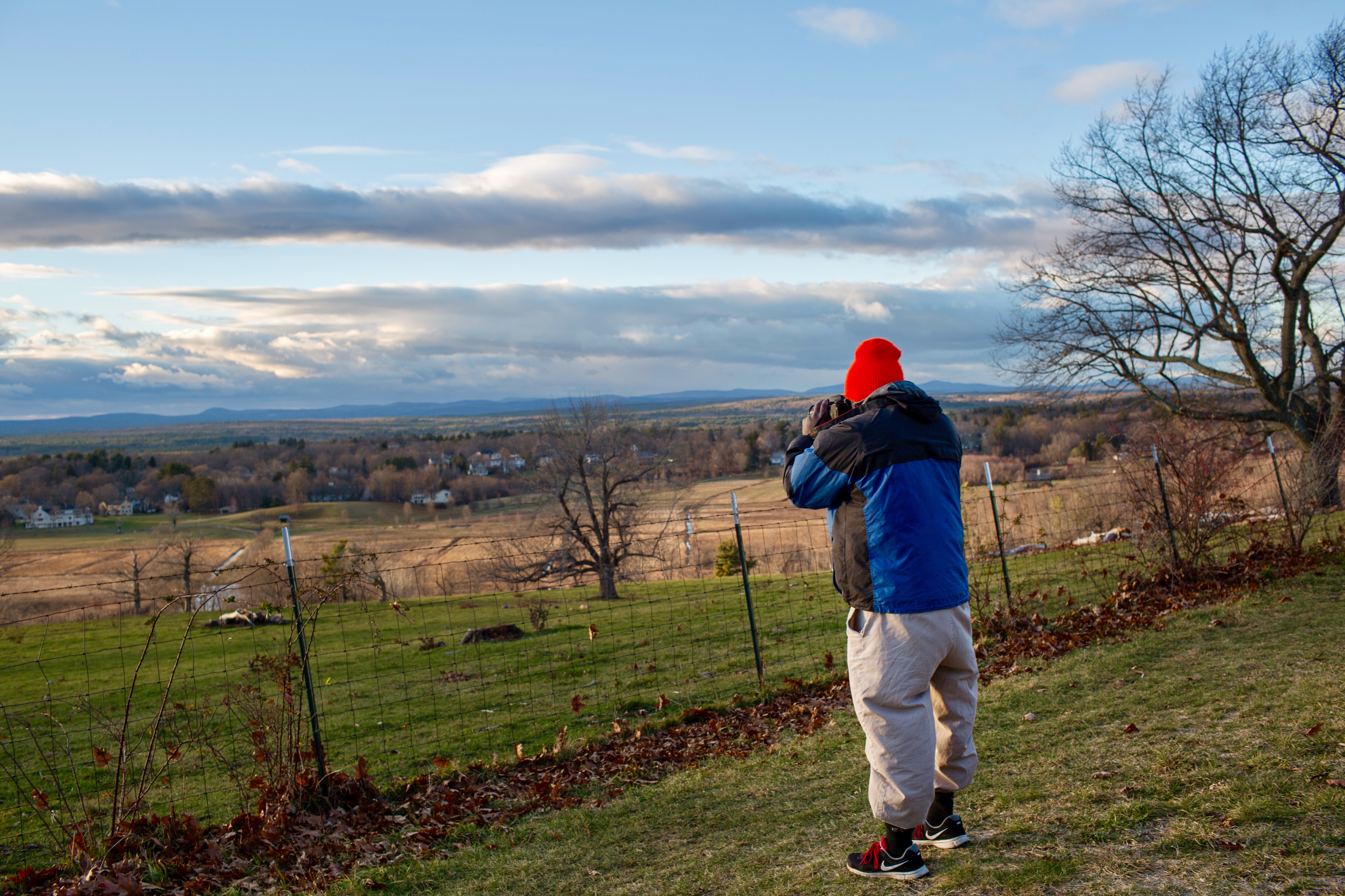 A hiker tries to capture the view from the top of a hill.
