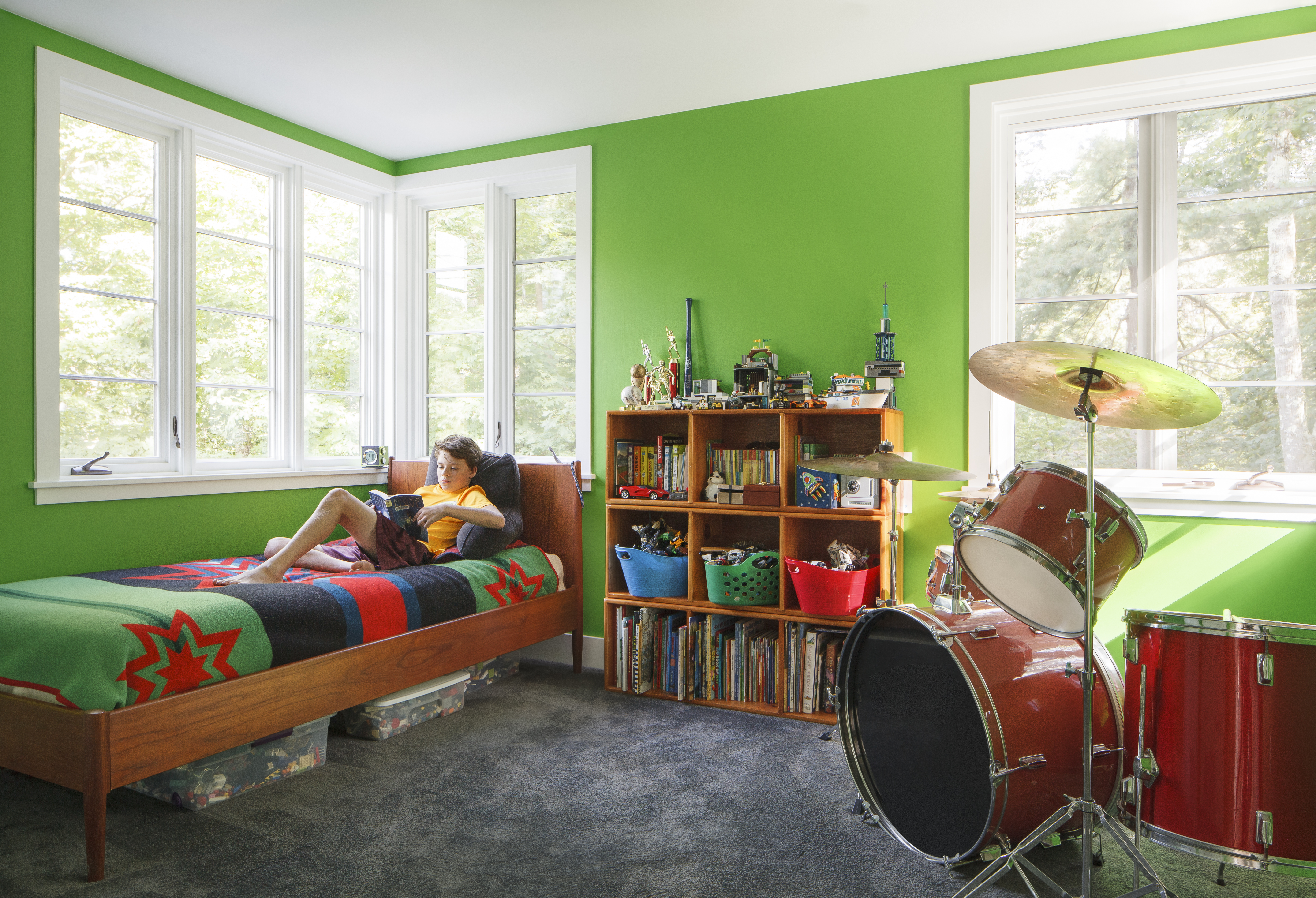 Twelve-year-old Alexei reads in his new bedroom, which is painted Benjamin Moore Tropical Seaweed.