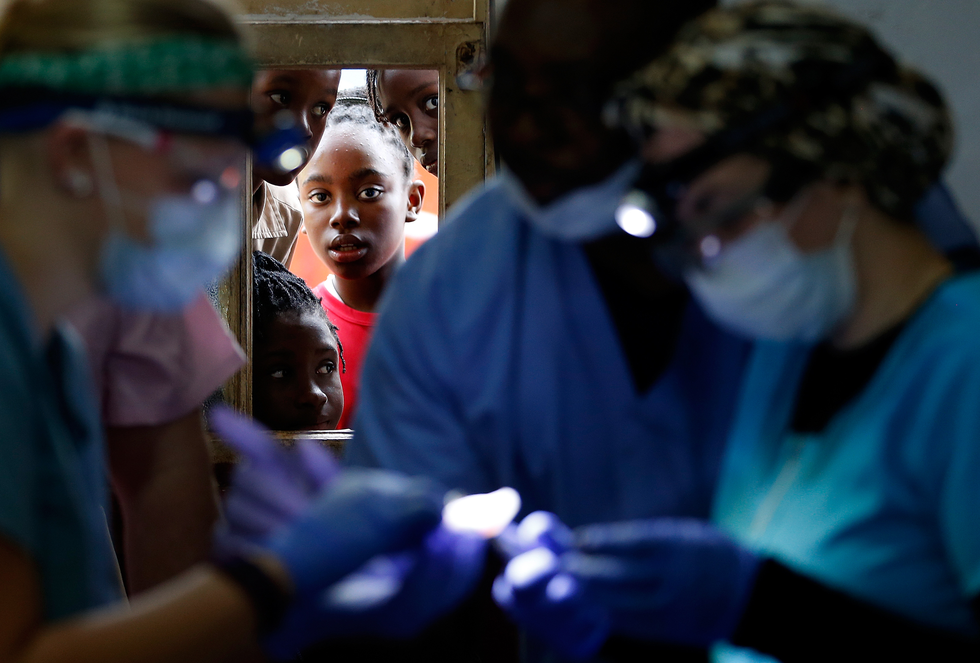 Children peered through the windows to watch as patients had their teeth extracted inside the makeshift dental clinic in Mount Moriah, Jamaica.