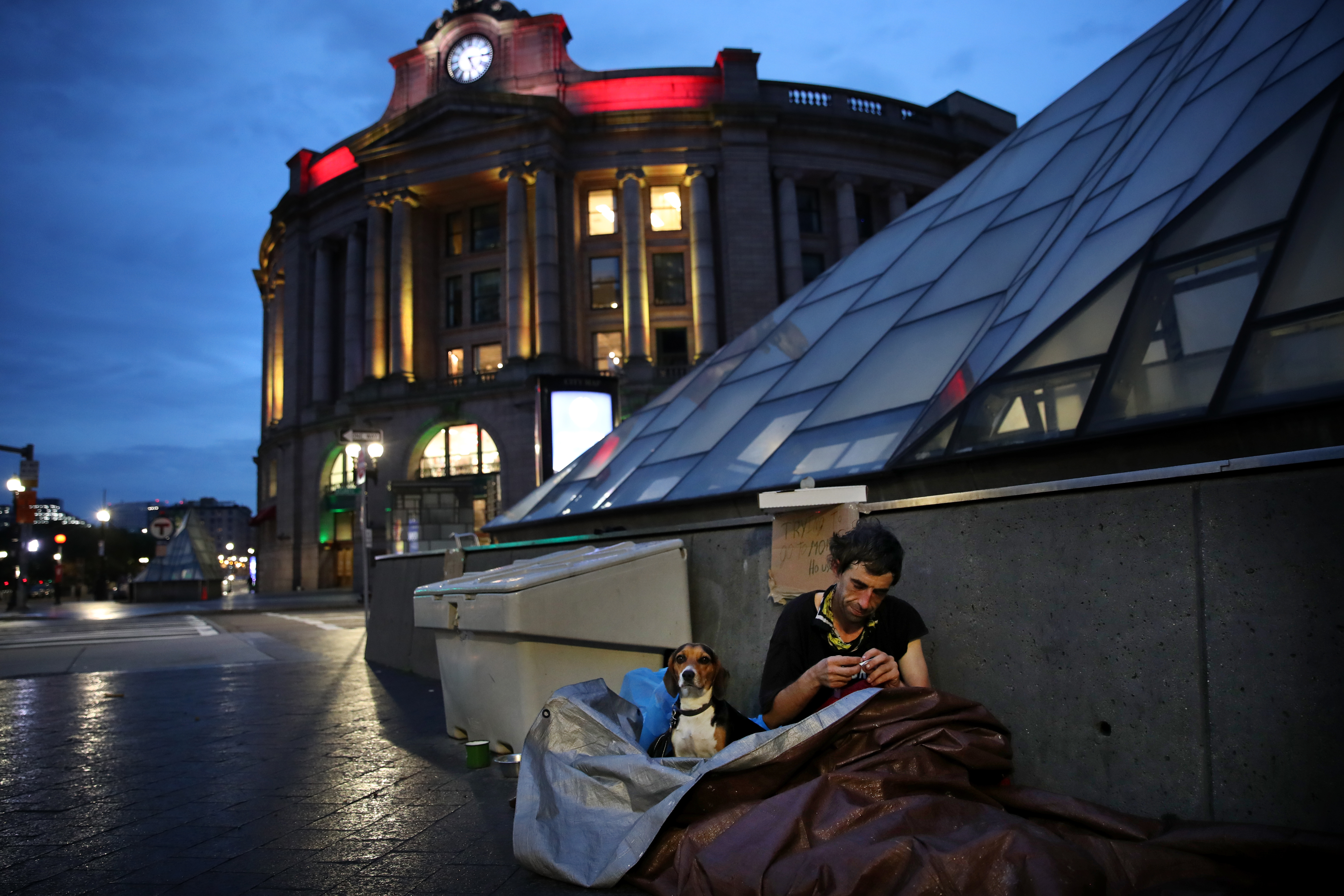 Jonathan Raulino rolled a cigarette after waking up with his dog, Miss Elle, outside South Station.