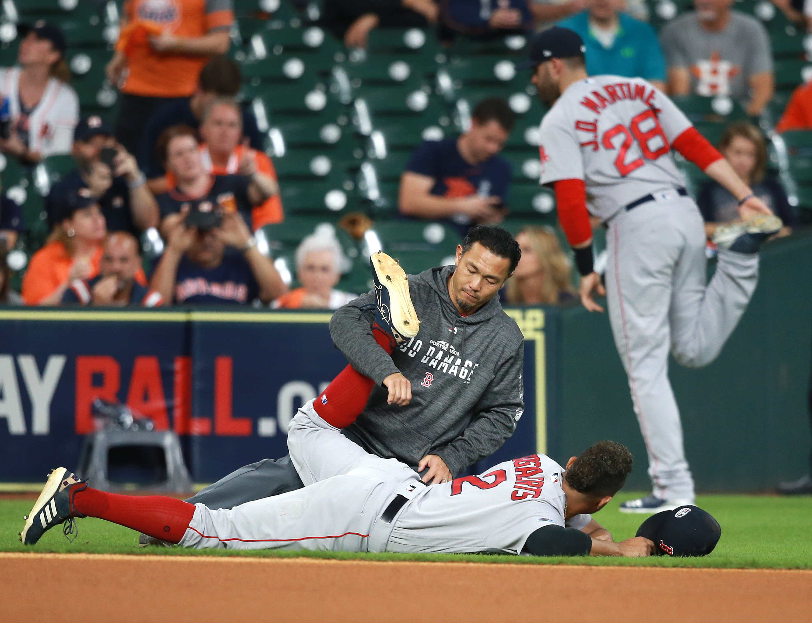 Red Sox players Xander Bogaerts (on ground) and J.D. Martinez had their own methods of stretching prior to Game 5.