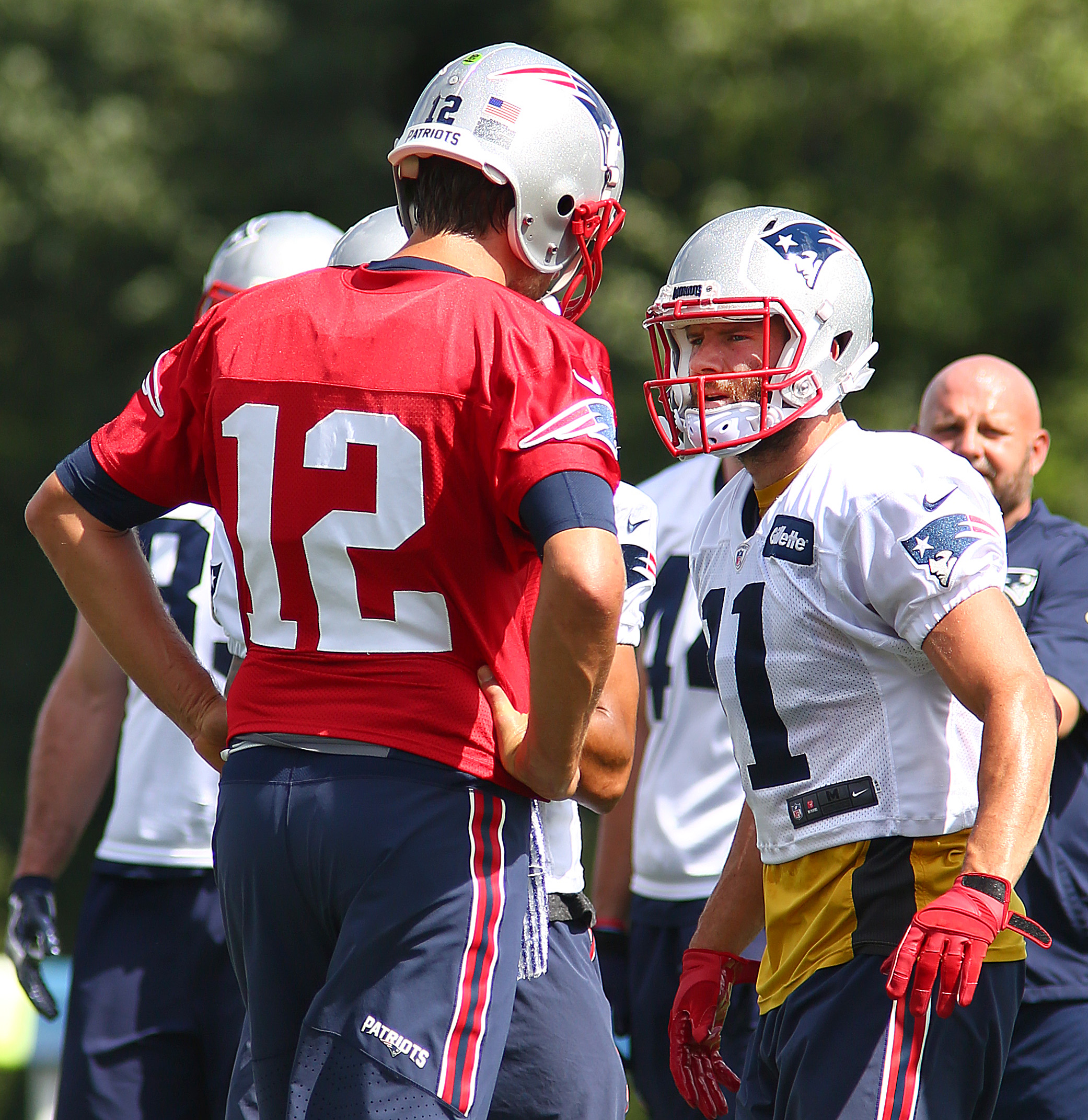 Tom Brady (left) conferred with receiver Julian Edelman at Sunday’s practice.