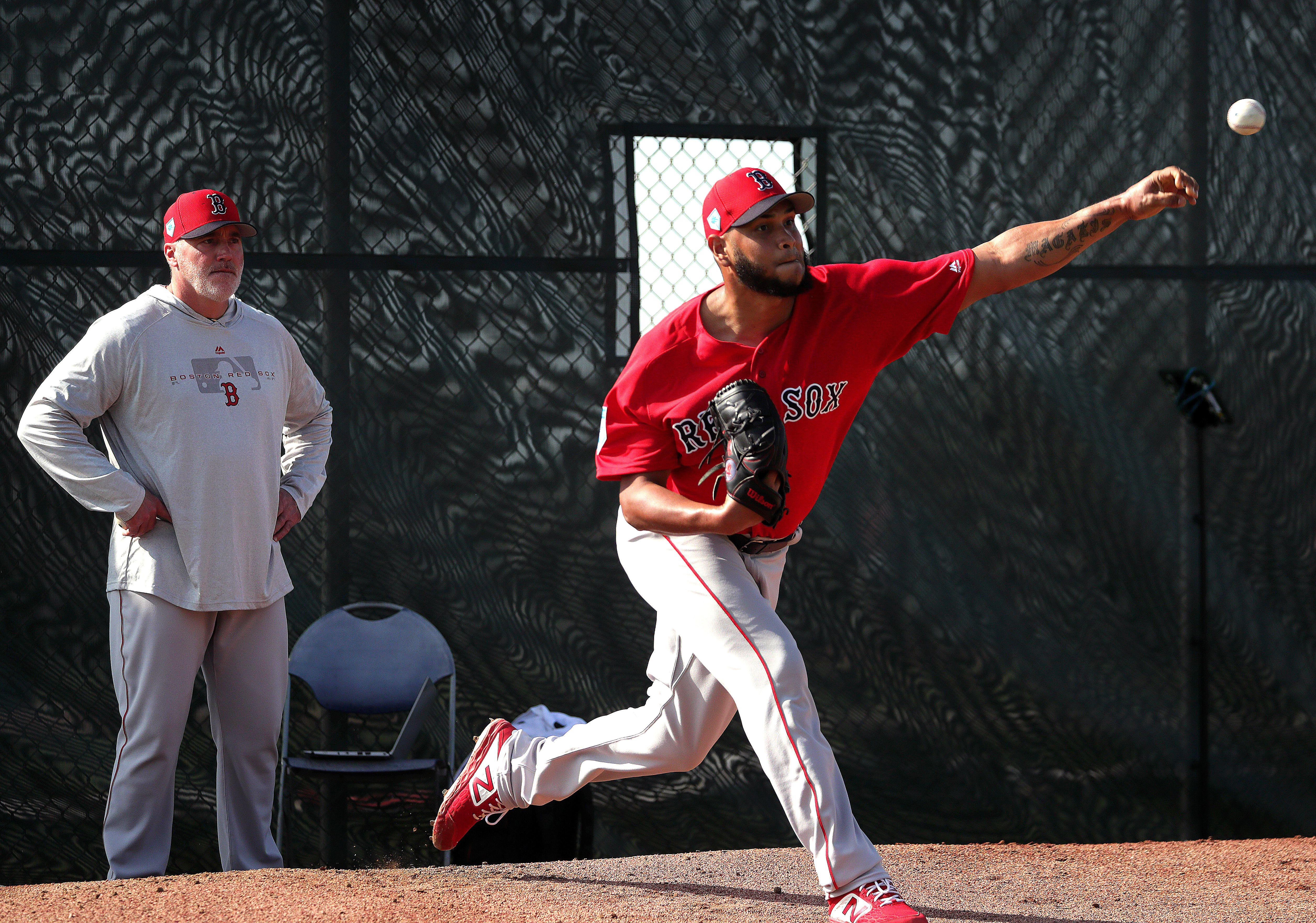 Eduardo Rodriguez throws a bullpen session as pitching coach Dana LeVangie looks on.