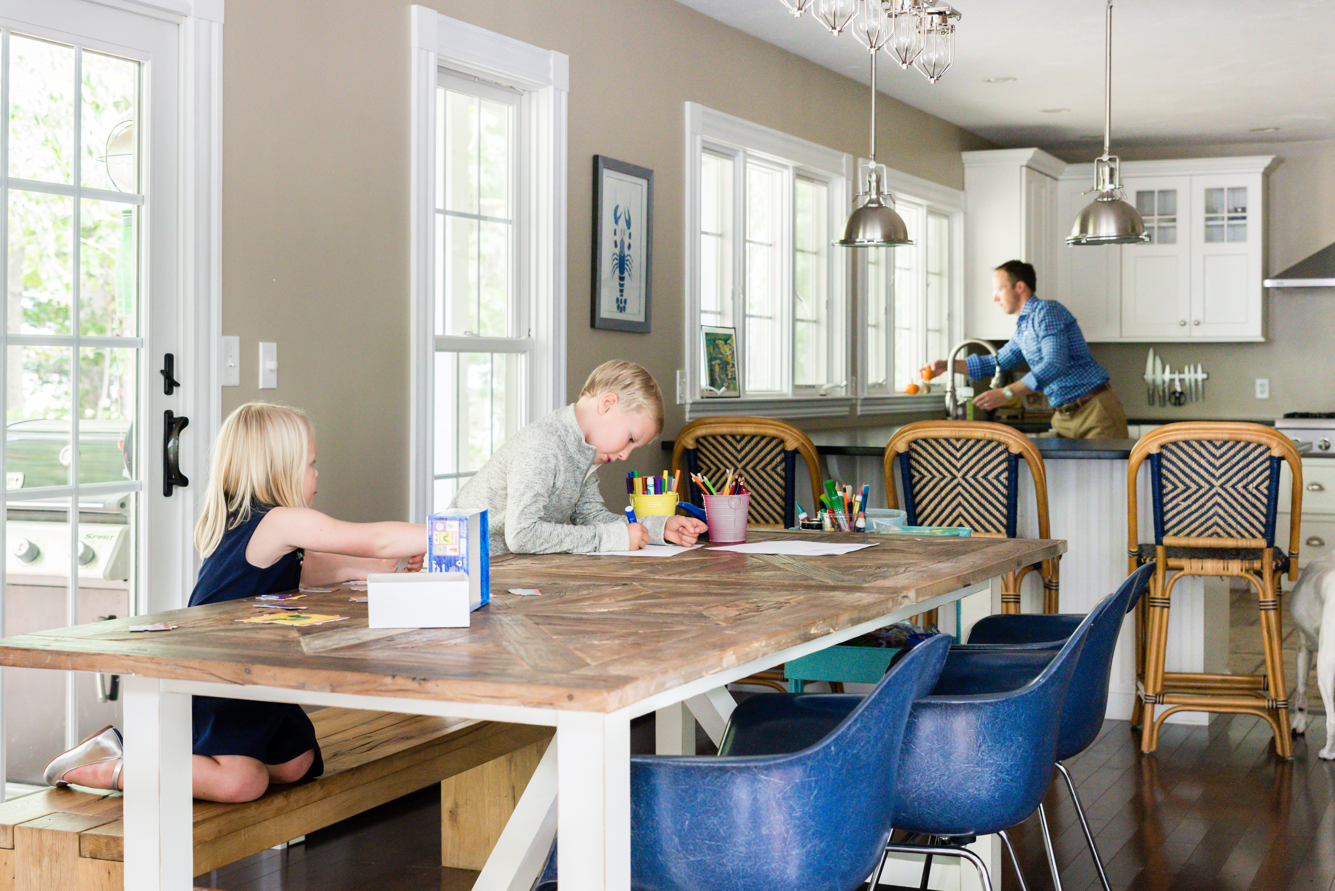Tess and Emmett color while Will preps a meal. The Restoration Hardware kitchen table has a rustic wood top, and the blue chairs are from Design Within Reach. A large part of the home’s appeal was its open floor plan. “I love how I can be cooking in the kitchen and the kids are right nearby,” says Lindsey.