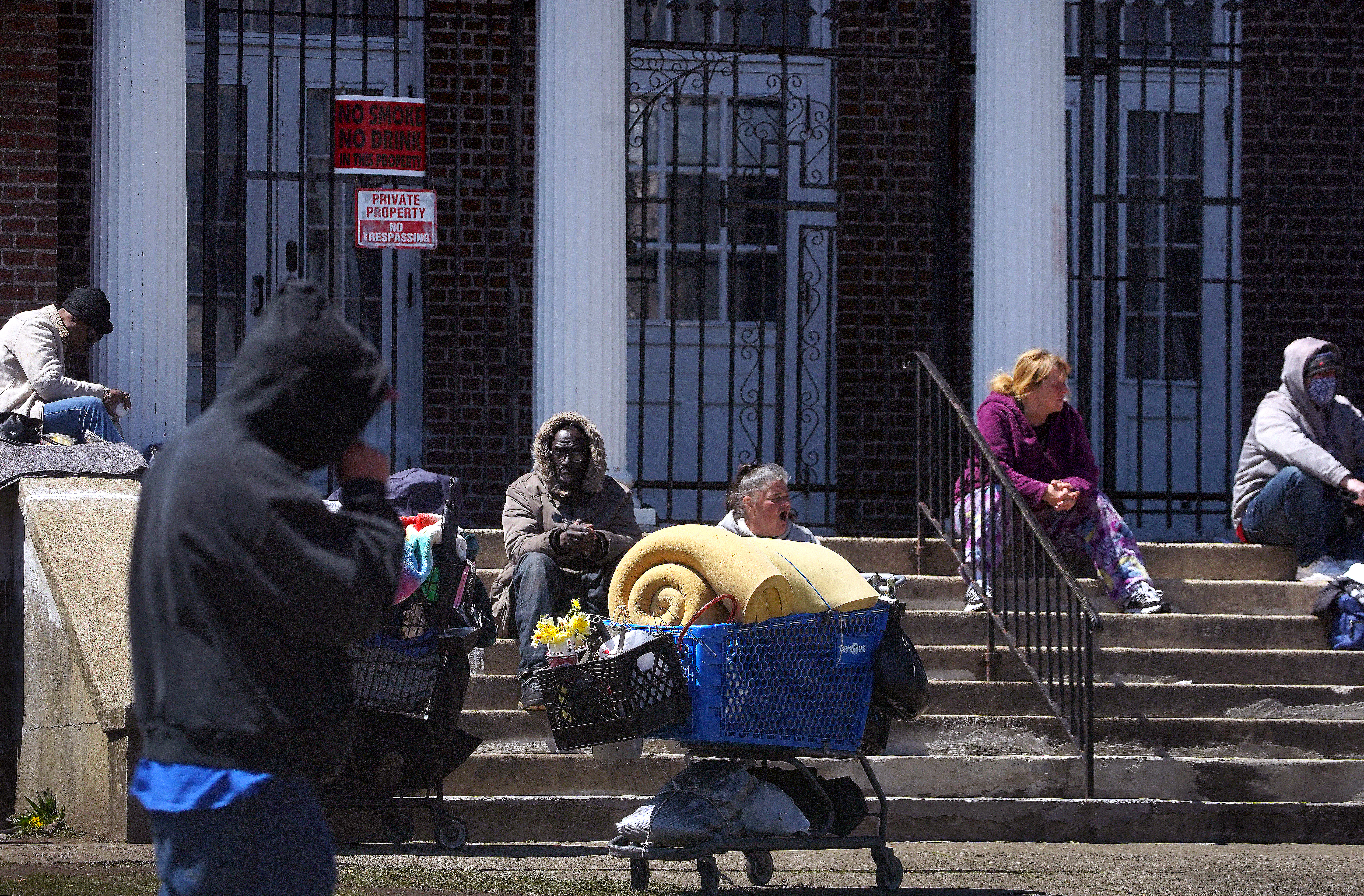 Homeless people congregate on the steps of the former Keys Of The Kingdom Tabernacle Of Prayer on Main Street in Brockton.