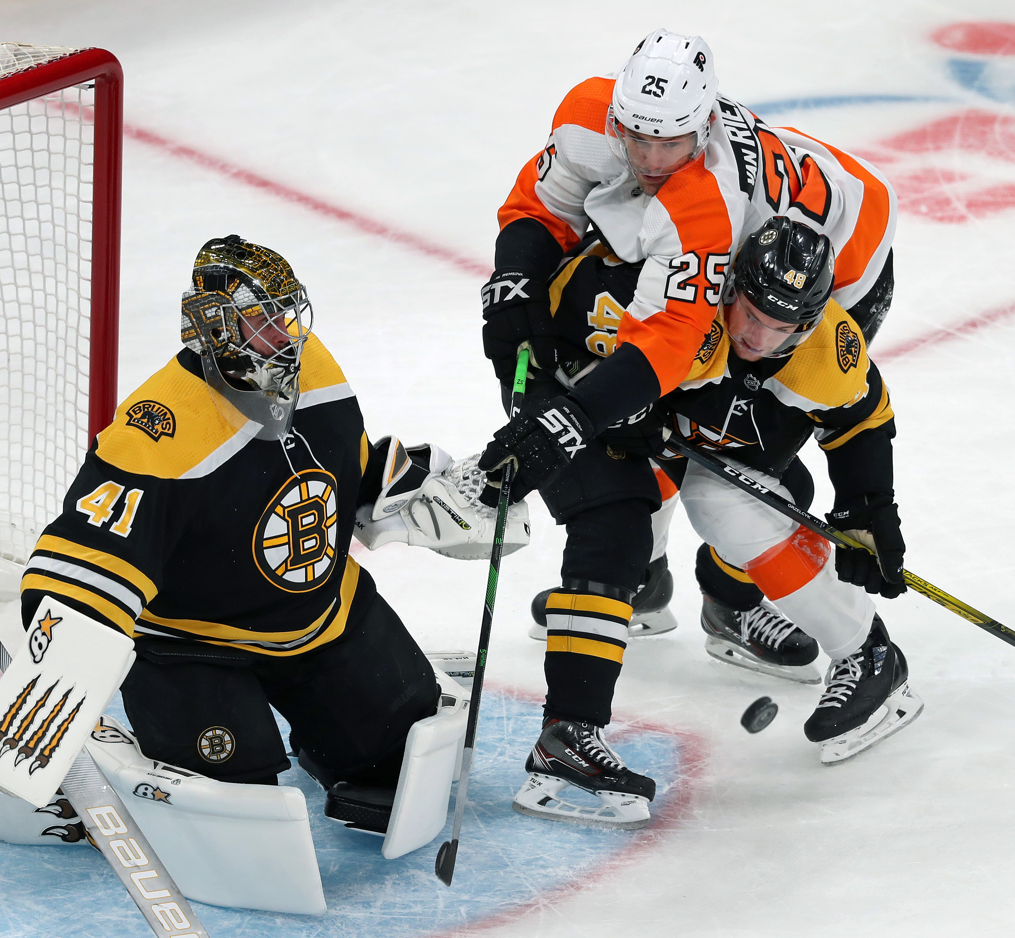 Flyers forward James van Riemsdyk rides Bruins defensman Matt Grzelcyk in front of Boston goalie Jaroslav Halak in the first period.