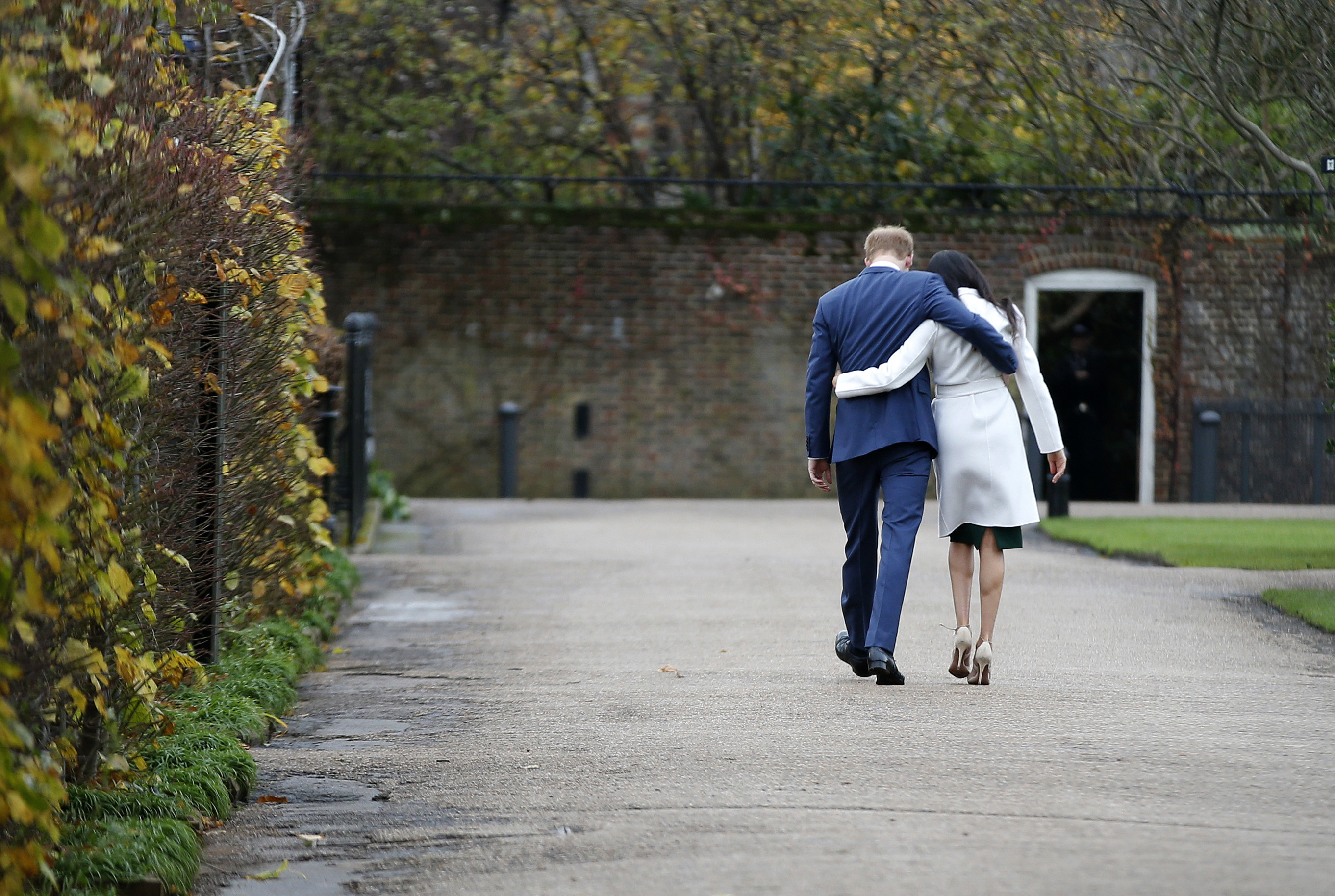 Britain's Prince Harry and Meghan Markle walked away after posing for the media in the grounds of Kensington Palace in London on Monday.