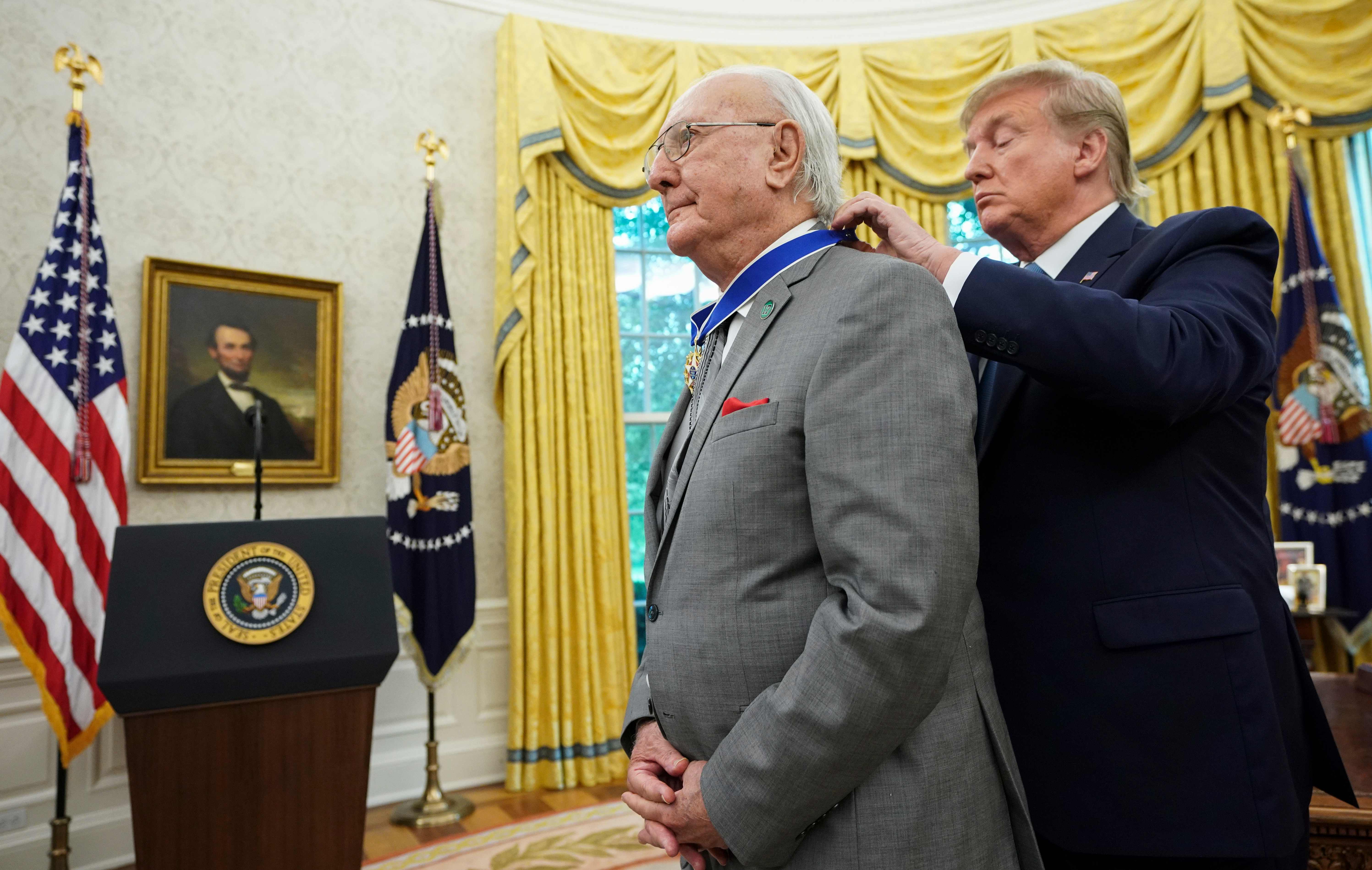 Trump placed the medal around Cousy’s neck.