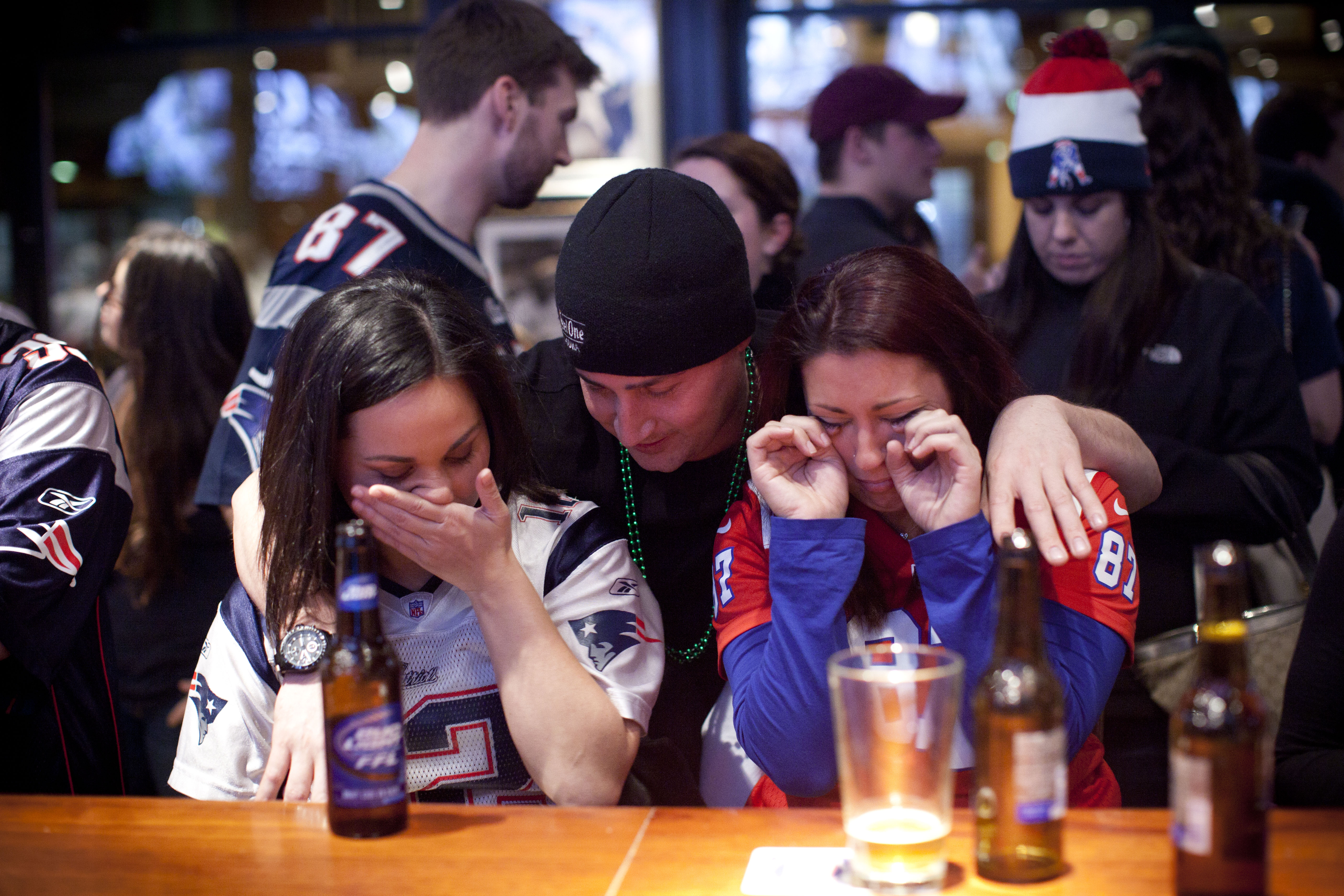 At the Cask ’n Flagon, Timothy Pesa comforted Danielle Shiner (right) and Kristin Feltz, all of Brighton.
