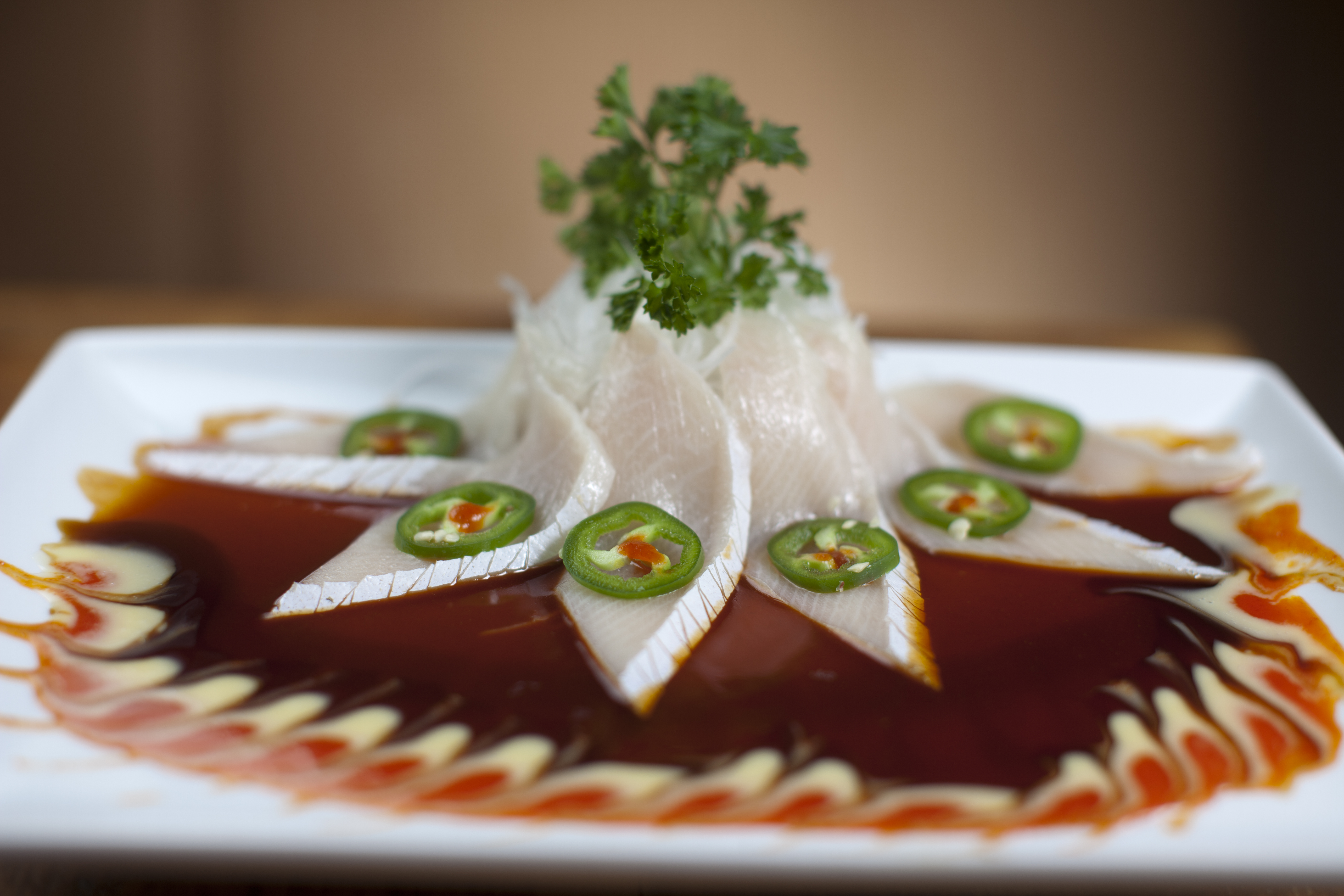 Sashimi topped with chili slices and shaved daikon.