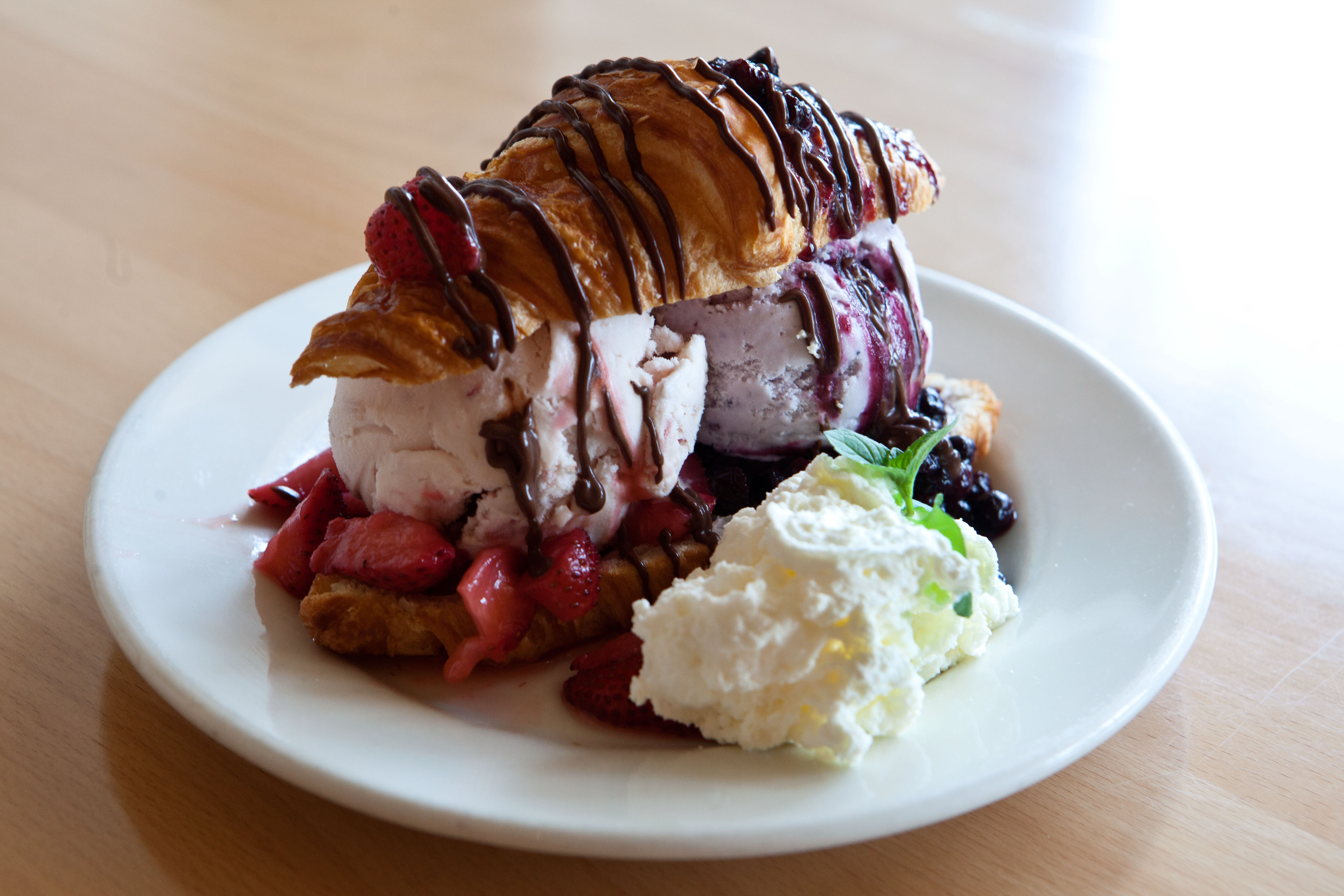 The Lobster Tail Sundae, served at New City Microcreamery, is made with a croissant, two scoops of ice cream, hot fudge, whipped cream, and berries.