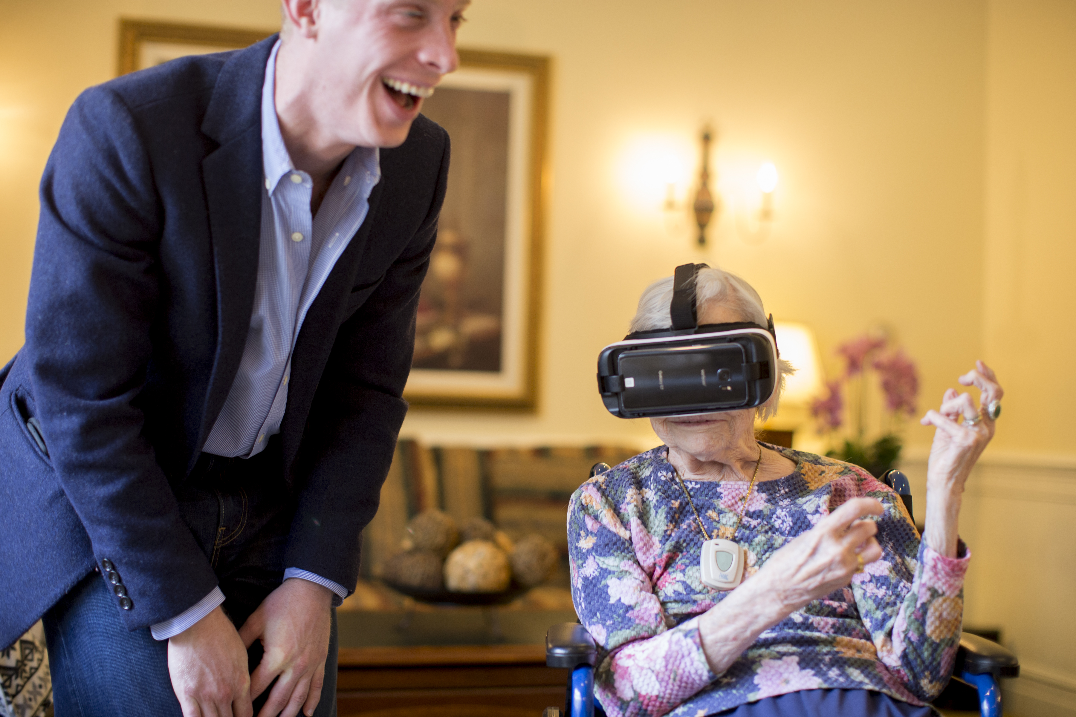 Doris Nakashian, 93, a senior at the Orchard Hill assisted living facility in Sudbury, was transported to various places in a virtual reality demonstration with the assistance of Dennis Lally (left).