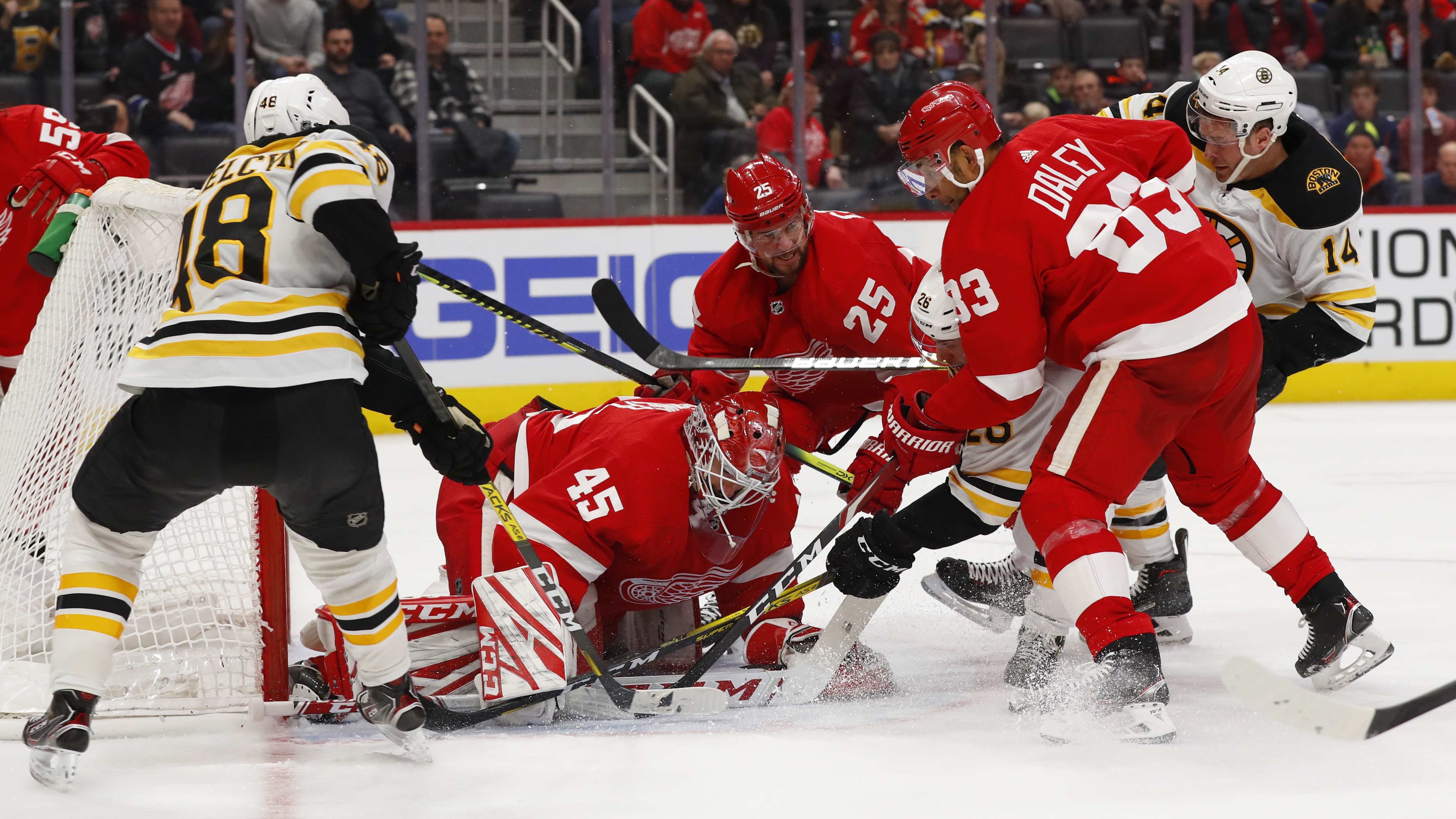 Red Wings goaltender Jonathan Bernier stops the puck in the midst of a crowd in the third period.