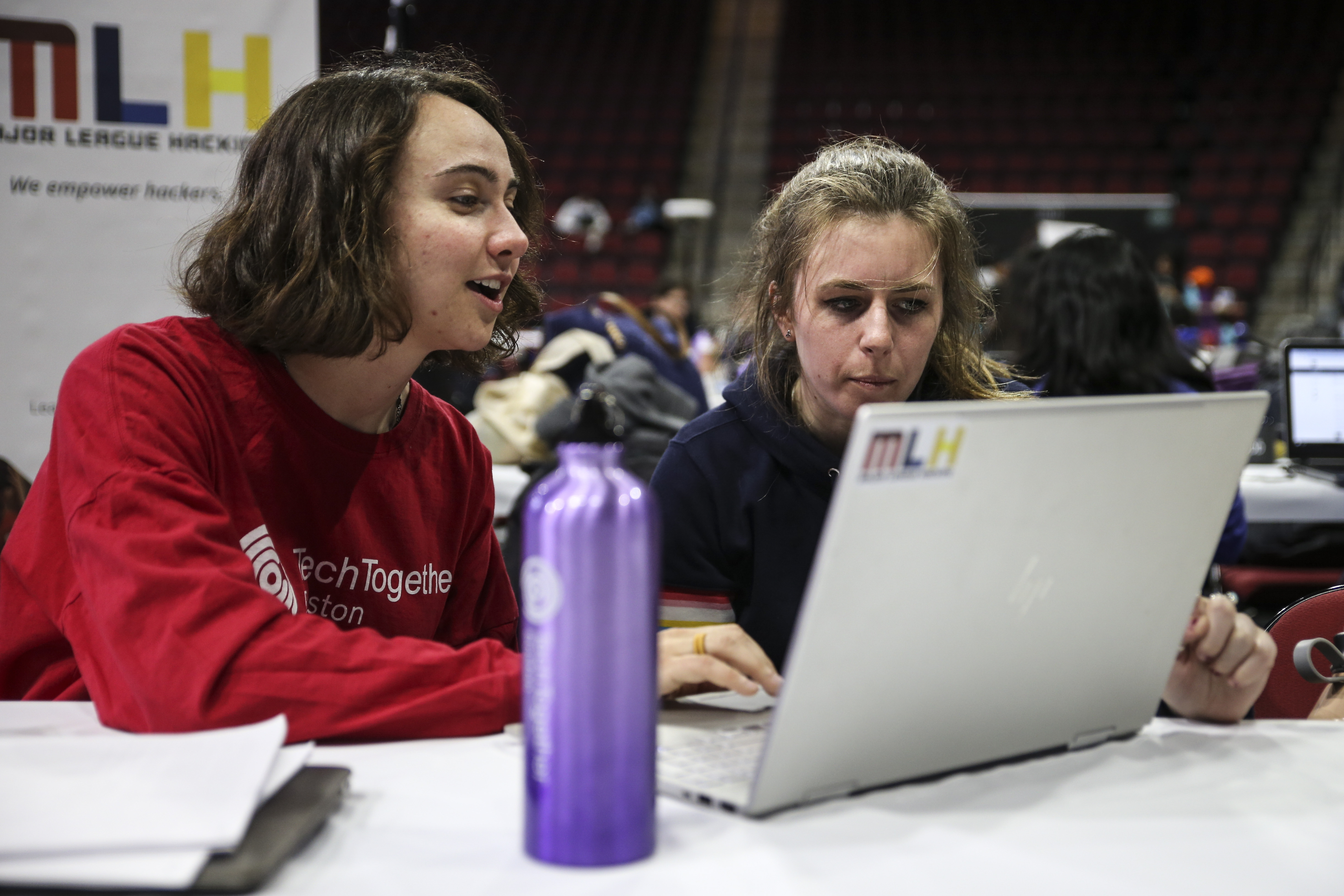 Rosalind Ellis (left) assisted Tessa McNeil, a student at BU, on a coding project during the TechTogether hackathon.
