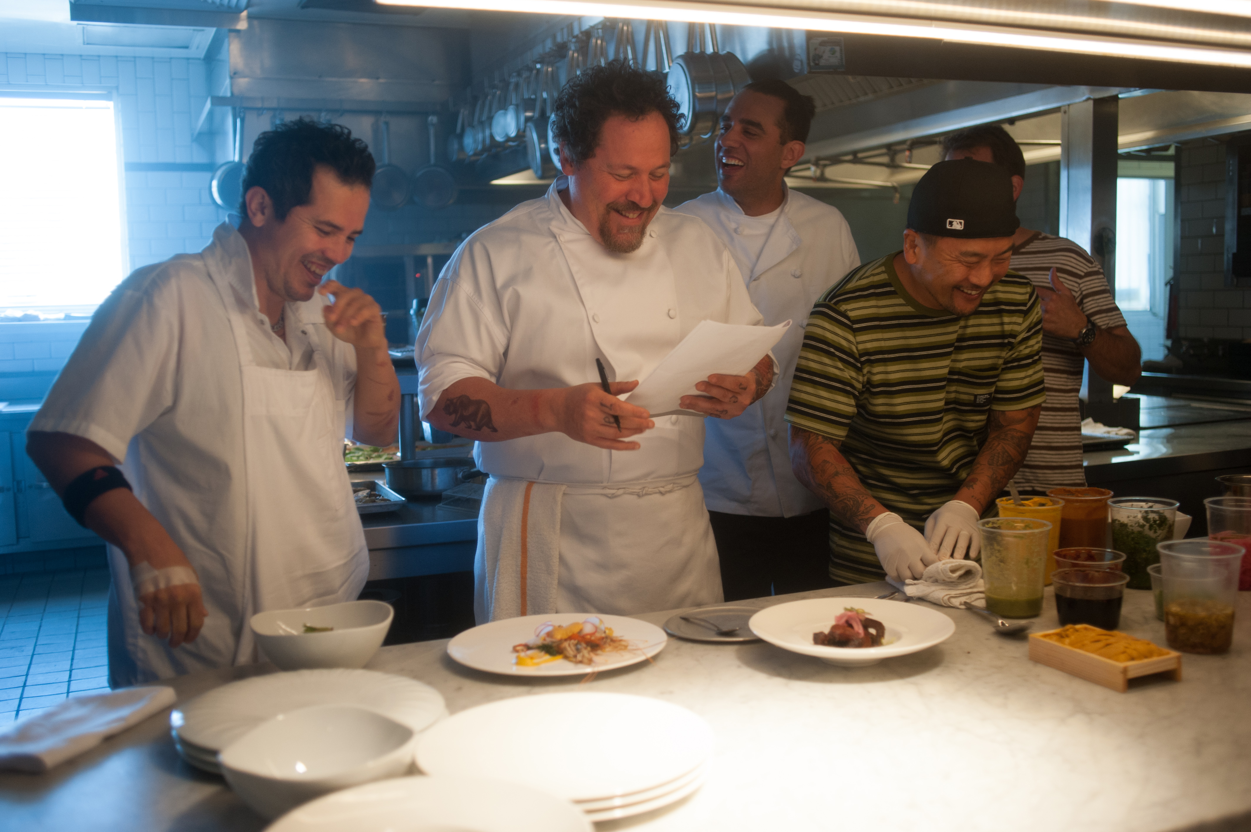 Behind the scenes during the making of “Chef”: (from left) John Leguizamo, who plays a line cook; Jon Favreau, who wrote, directed, and stars; Bobby Cannavale, who plays a sous chef, and Korean-American chef (and food-truck king) Roy Choi, who served as a technical consultant.