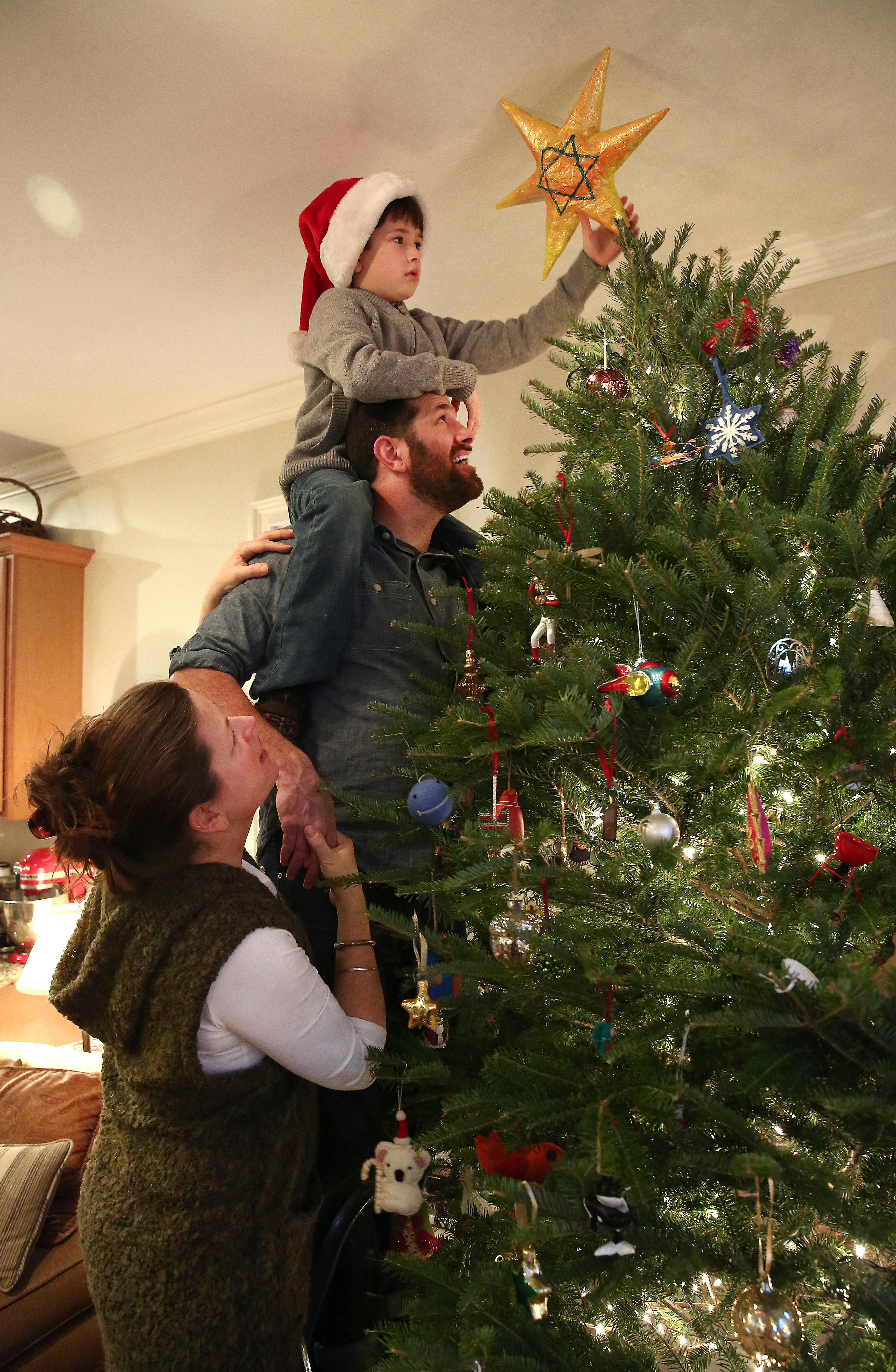 Karolyn Feeks Maws, a Christian, and her Jewish husband Tony Maws decorated their Christmas tree, with their 8-year-old son Charlie Maws, who is being raised in both traditions.