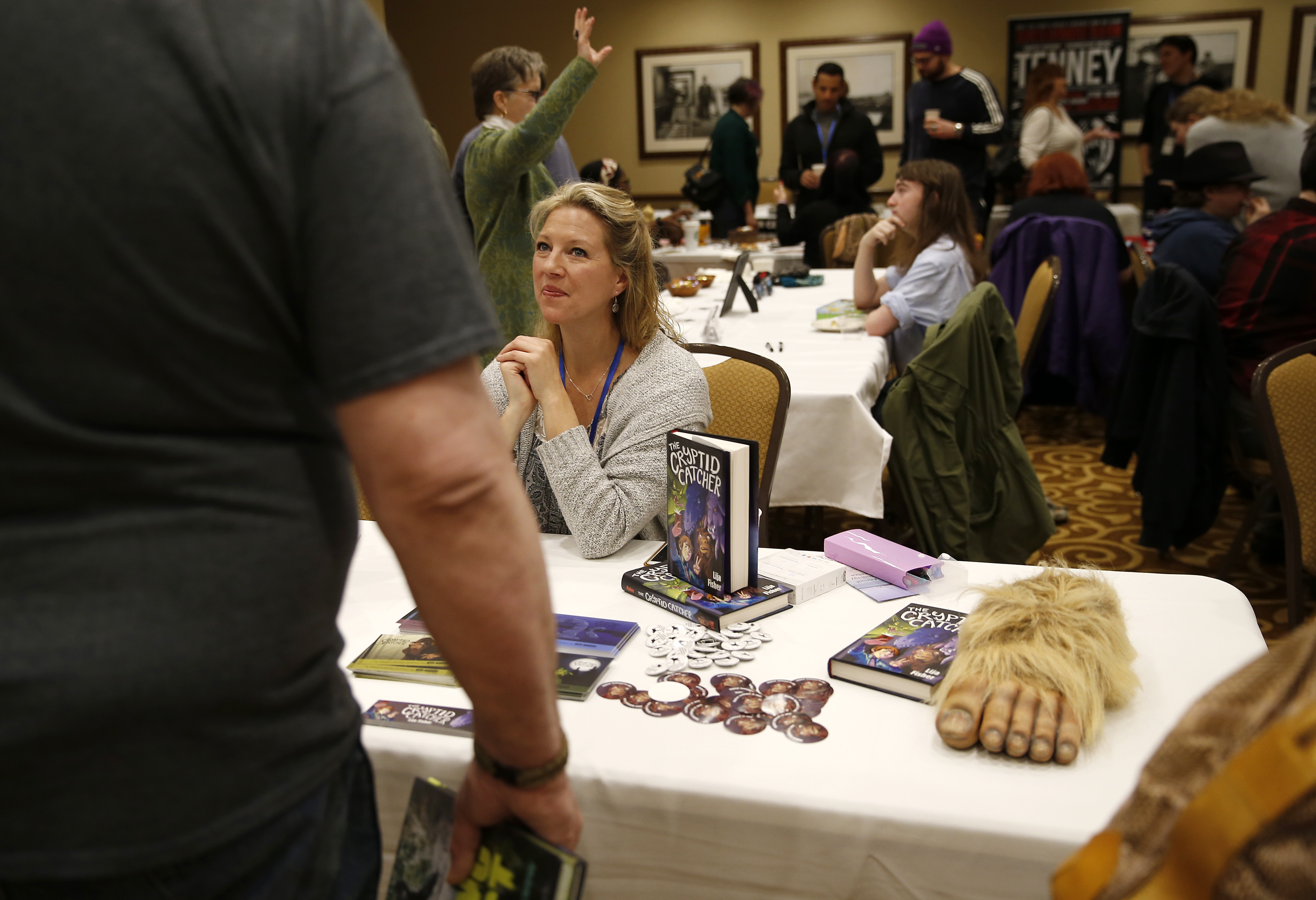 Lija Fisher (center), author of "The Cryptic Catcher," chatted with a convention goer.