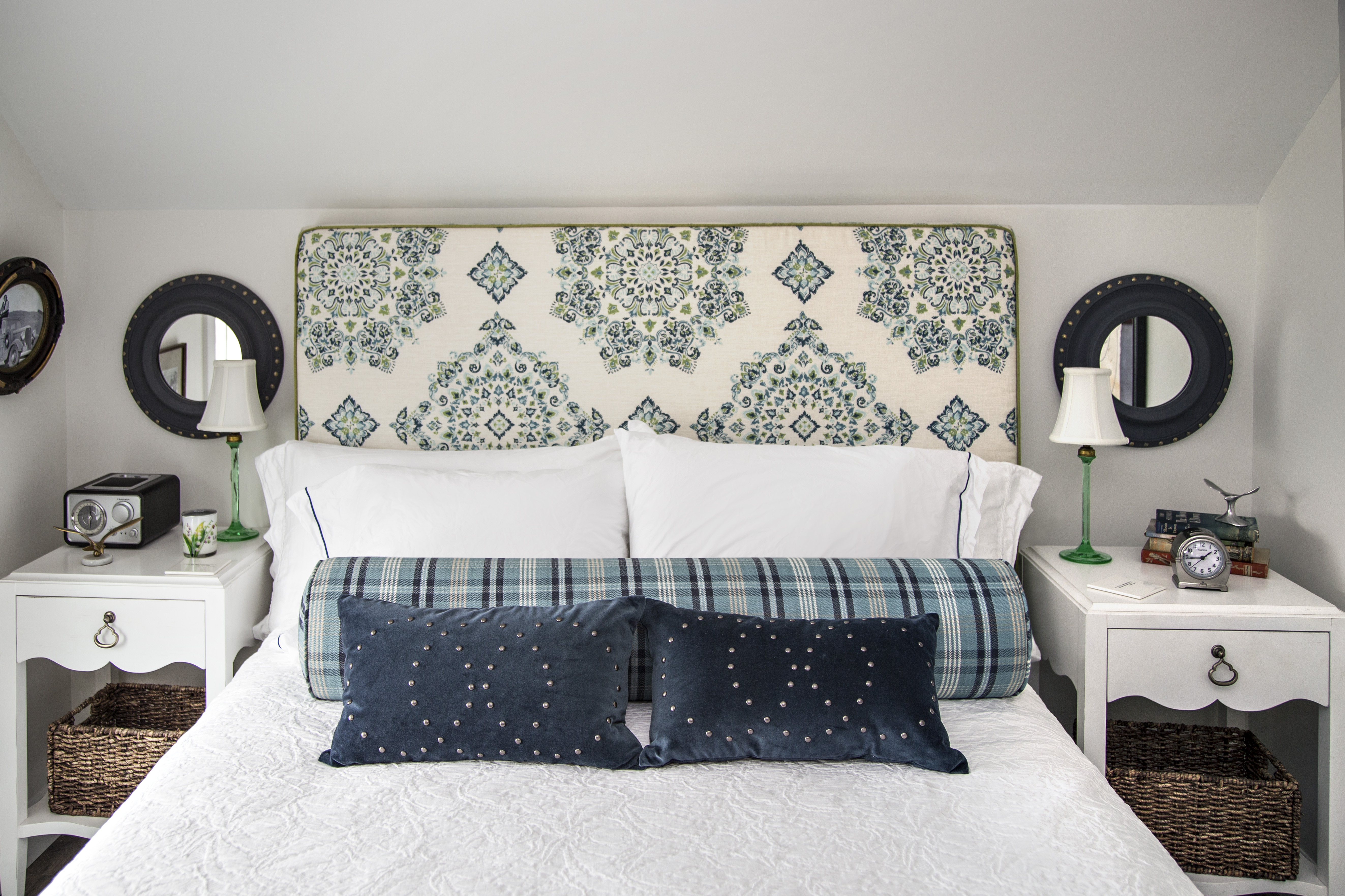 Mirrors above the end tables in the guest bedroom are tweaked to look like ship portholes.