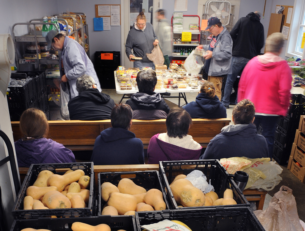 People waited on benches for their turn at the Irene Chadbourne Ecumenical Food Pantry on Main Street in Calais, Maine.