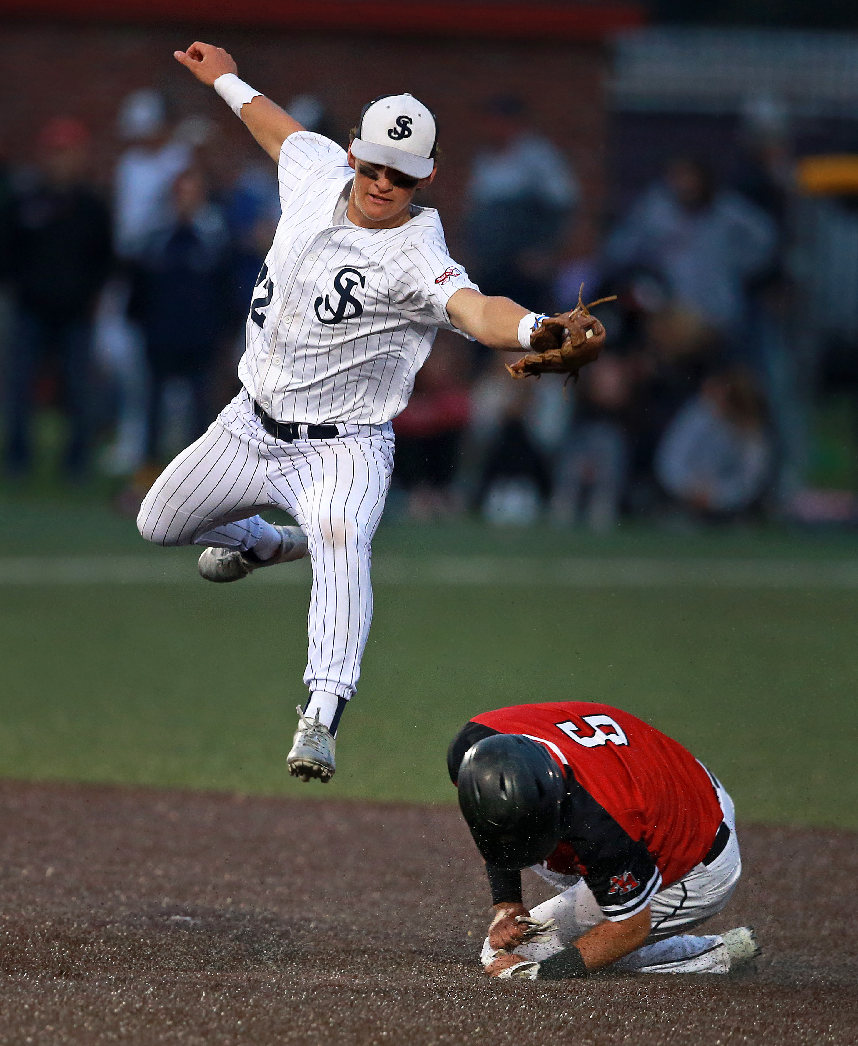 North Andover's Jake McElroy steals second base in the top of the fourth inning, St. John's Will Potdevin leaps to take the high throw.