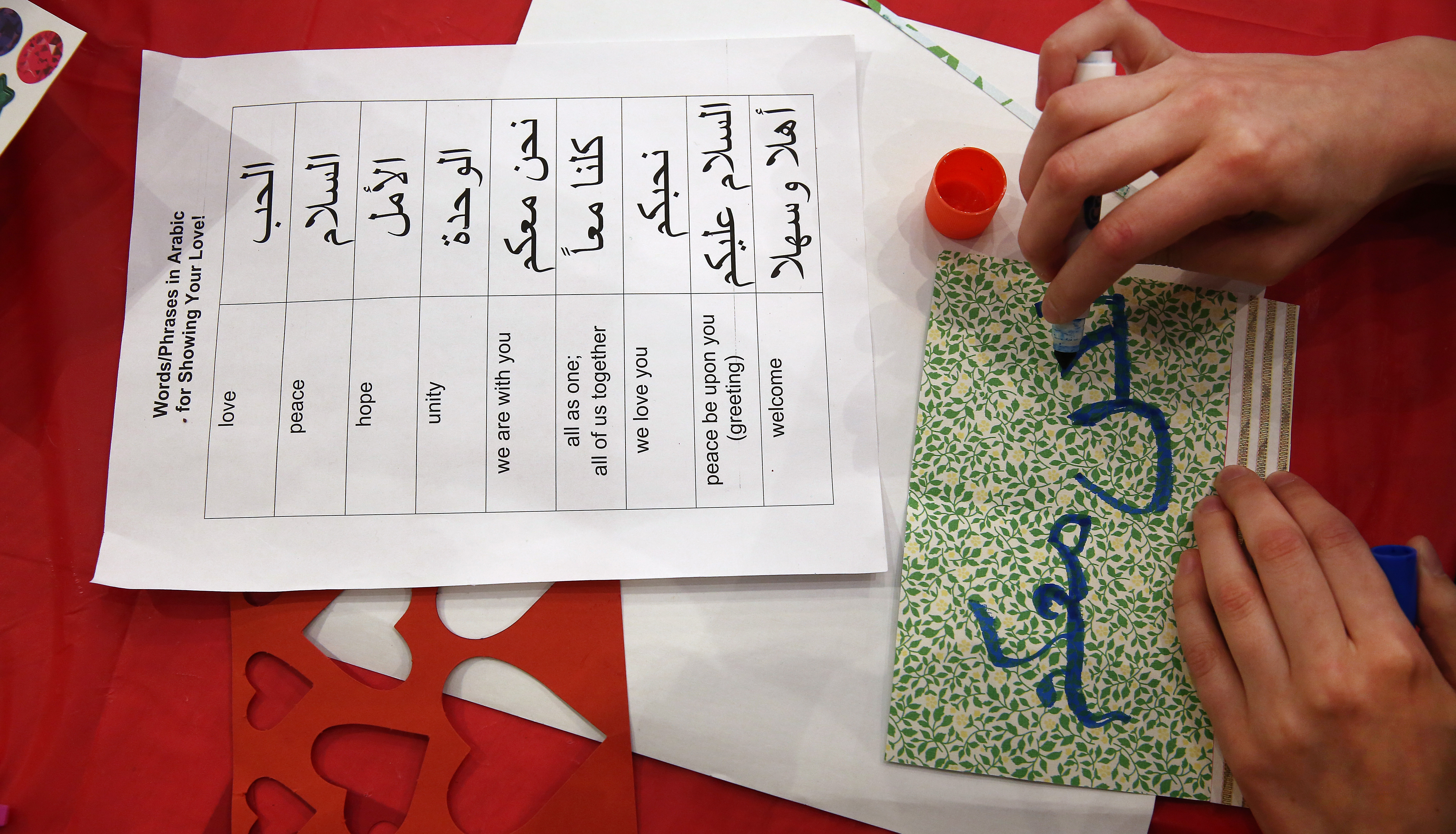 Madeline Bennett, a student at Massachusetts College of Art Design, copied the phrase "we are with you" on her card during a “To Islam, With Love” card-making marathon. Boston Latin Academy students studying Arabic created the guide.