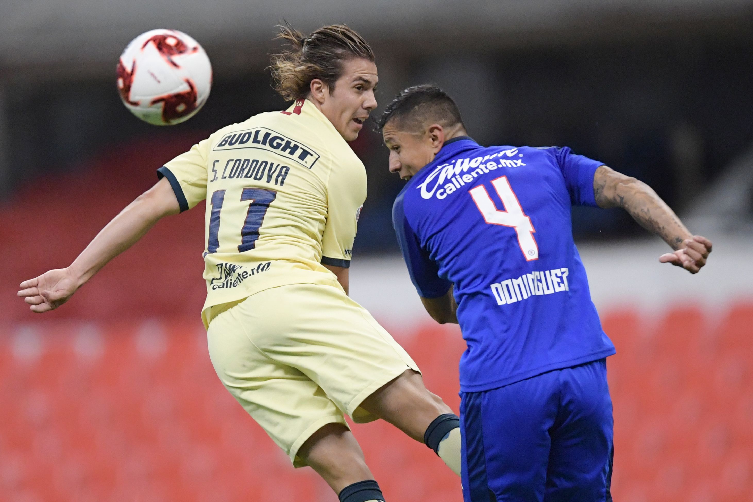 Cruz Azul's defender Julio Dominguez (R) jumps for the ball with America's midfielder Francisco Cordova during their Mexican Clausura tournament football match Sunday at Azteca Stadium, in Mexico City.