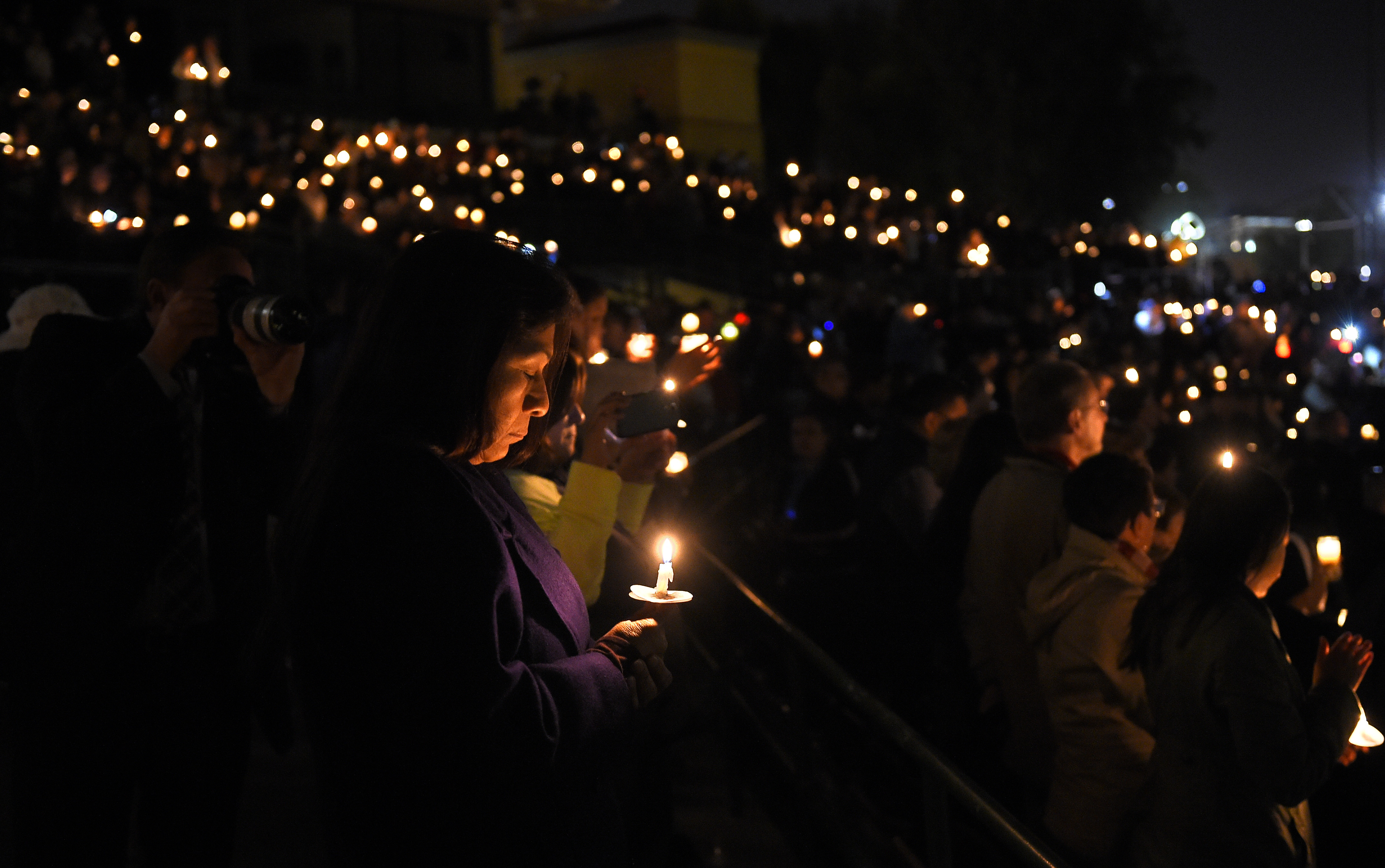 People held candles during a vigil for shooting victims on Thursday.