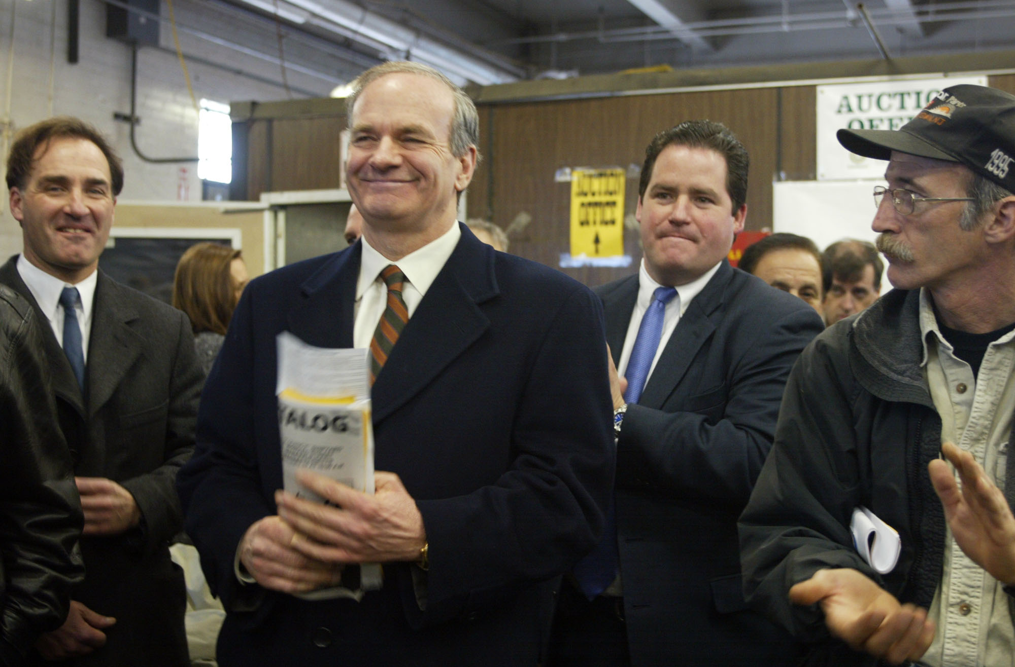 Dan Flynn (right) was joined by car dealership owner Dan Quirk of Braintree (center) and his attorney, Frank Marinelli (left) during an auction for the Fore River Shipyard land in Quincy in 2003. Barred by the US Dept. of Justice from working in real estate, Flynn was until recently selling cars at a Quirk Chevrolet in Braintree.