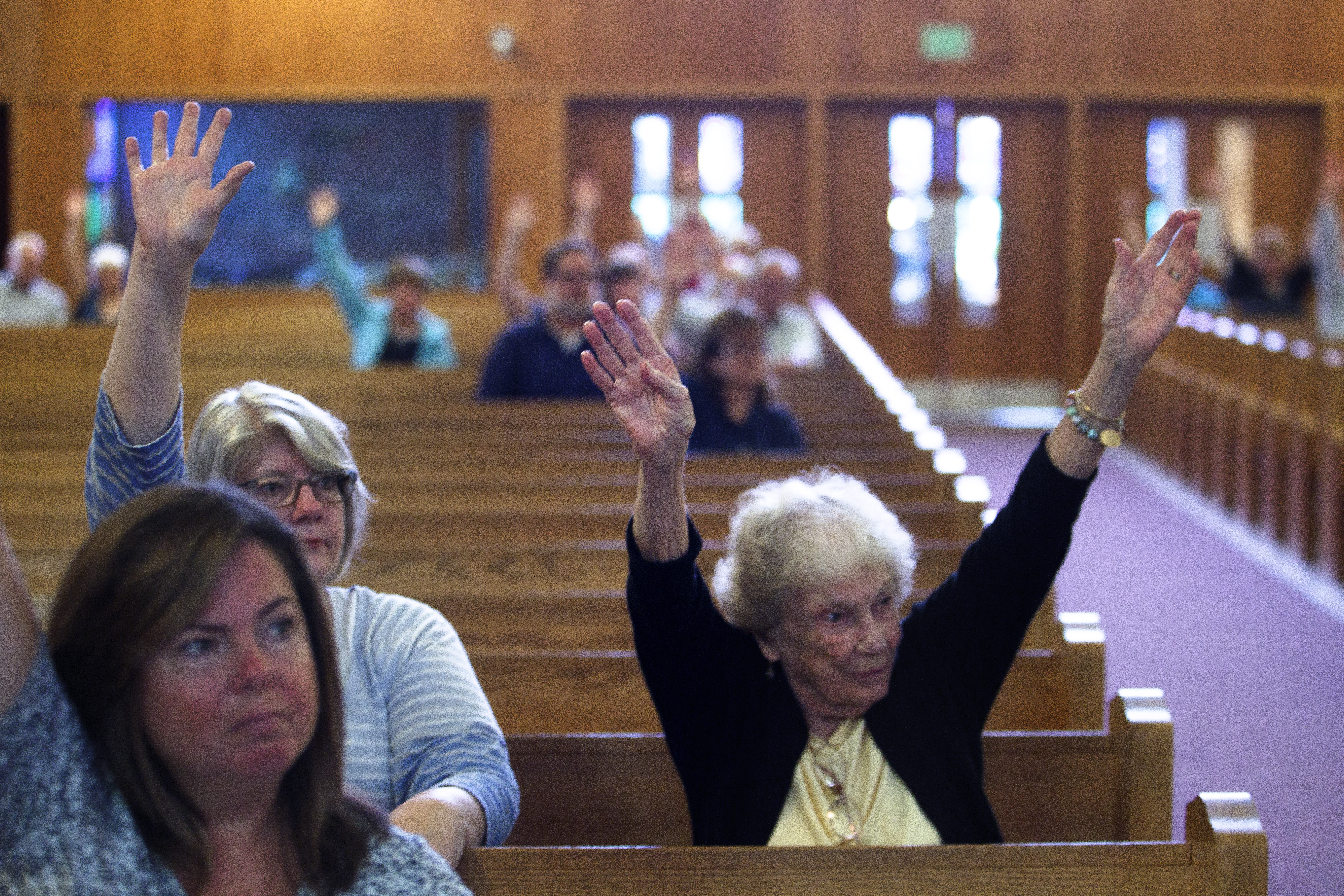 Margy O’Brien, of Scituate, voted with both arms to keep fighting to keep the St. Frances X. Cabrini parish open.
