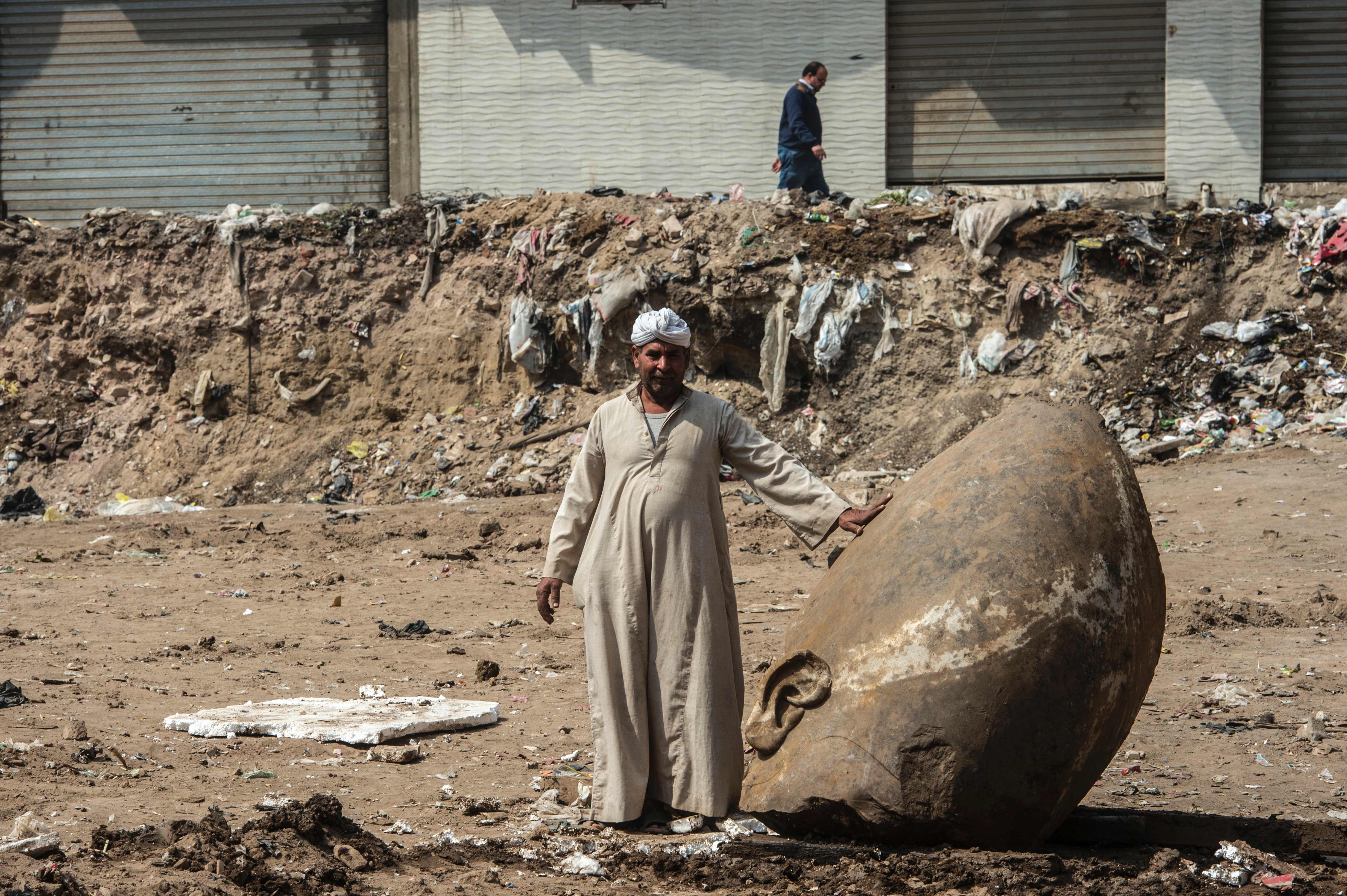 An Egyptian worker stood next to the statue’s head.