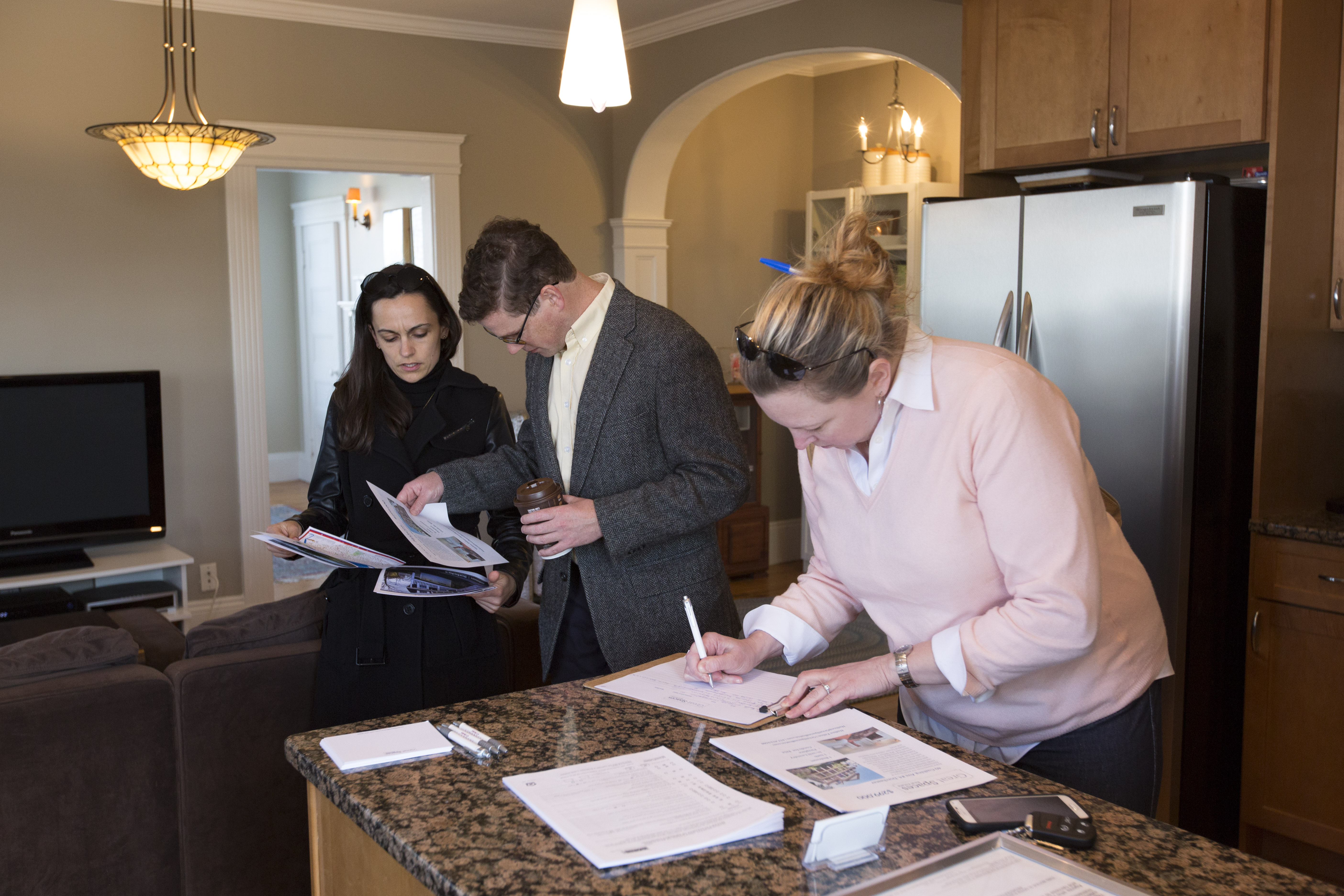 Maria Arabatzis (left) and Brian Egan, potential first-time home buyers, looked over marketing materials during an open house of a one-bedroom condo in Jones Hill in Dorchester.
